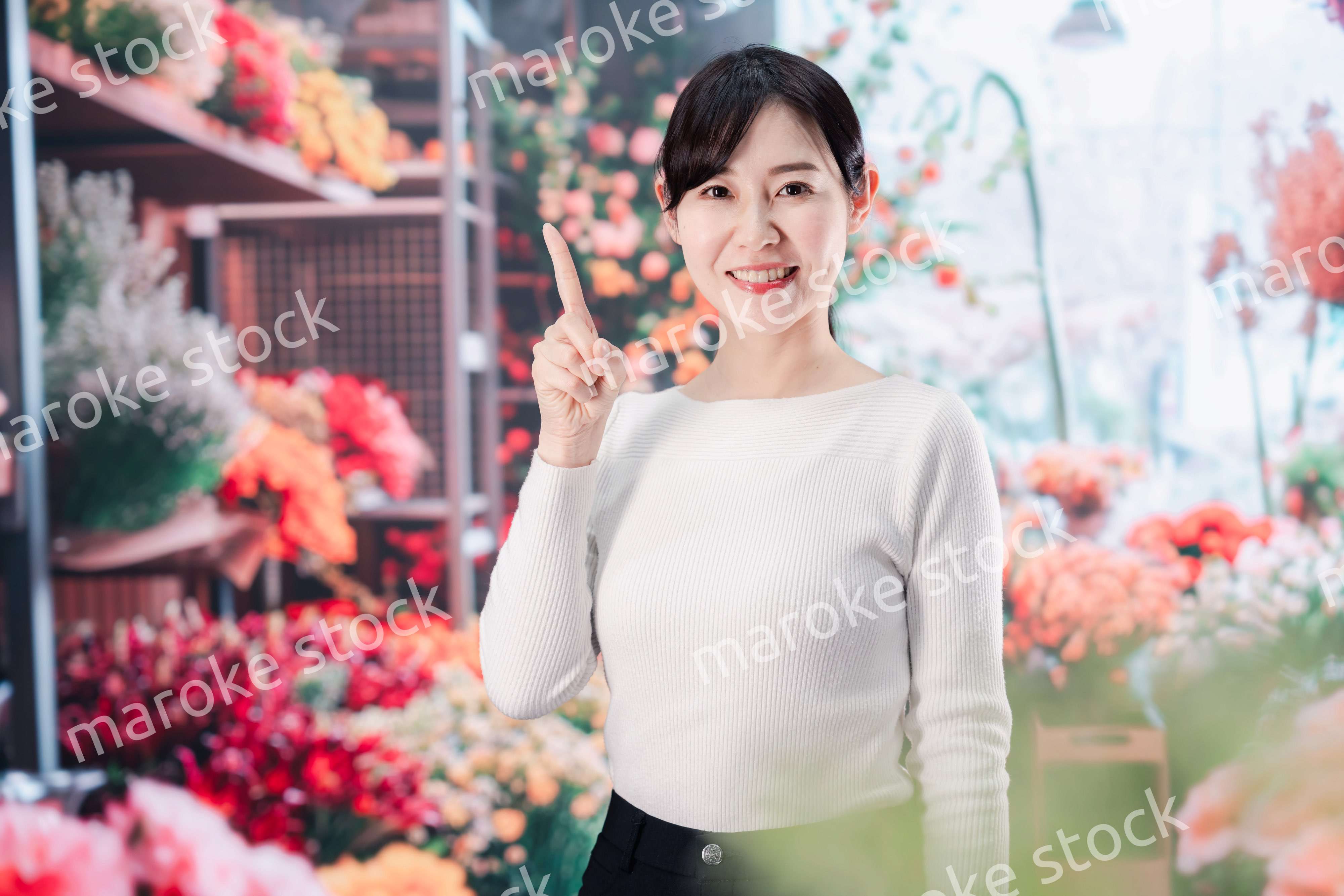 お花屋さんで花を選ぶ若い女性