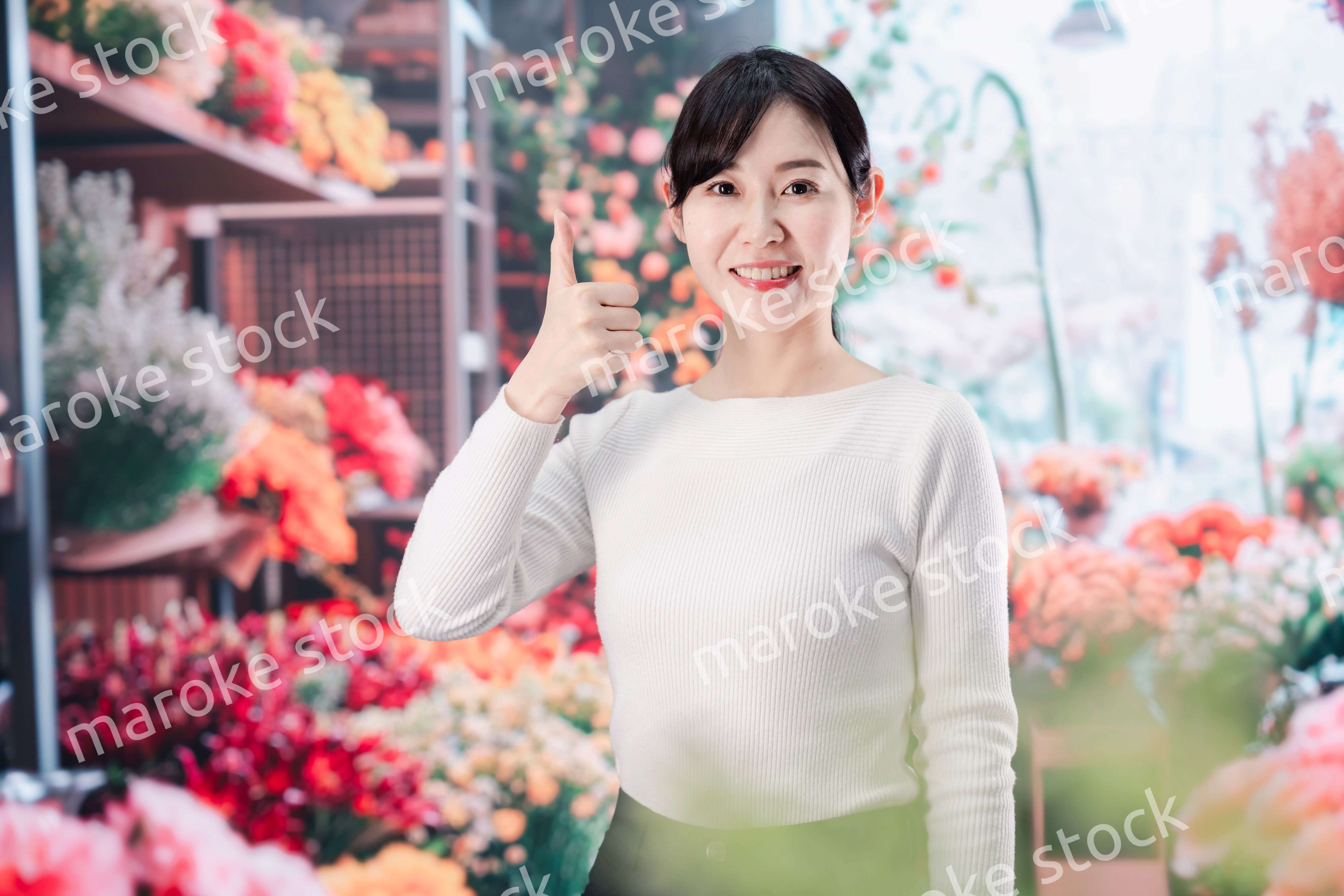 お花屋さんで花を選ぶ若い女性