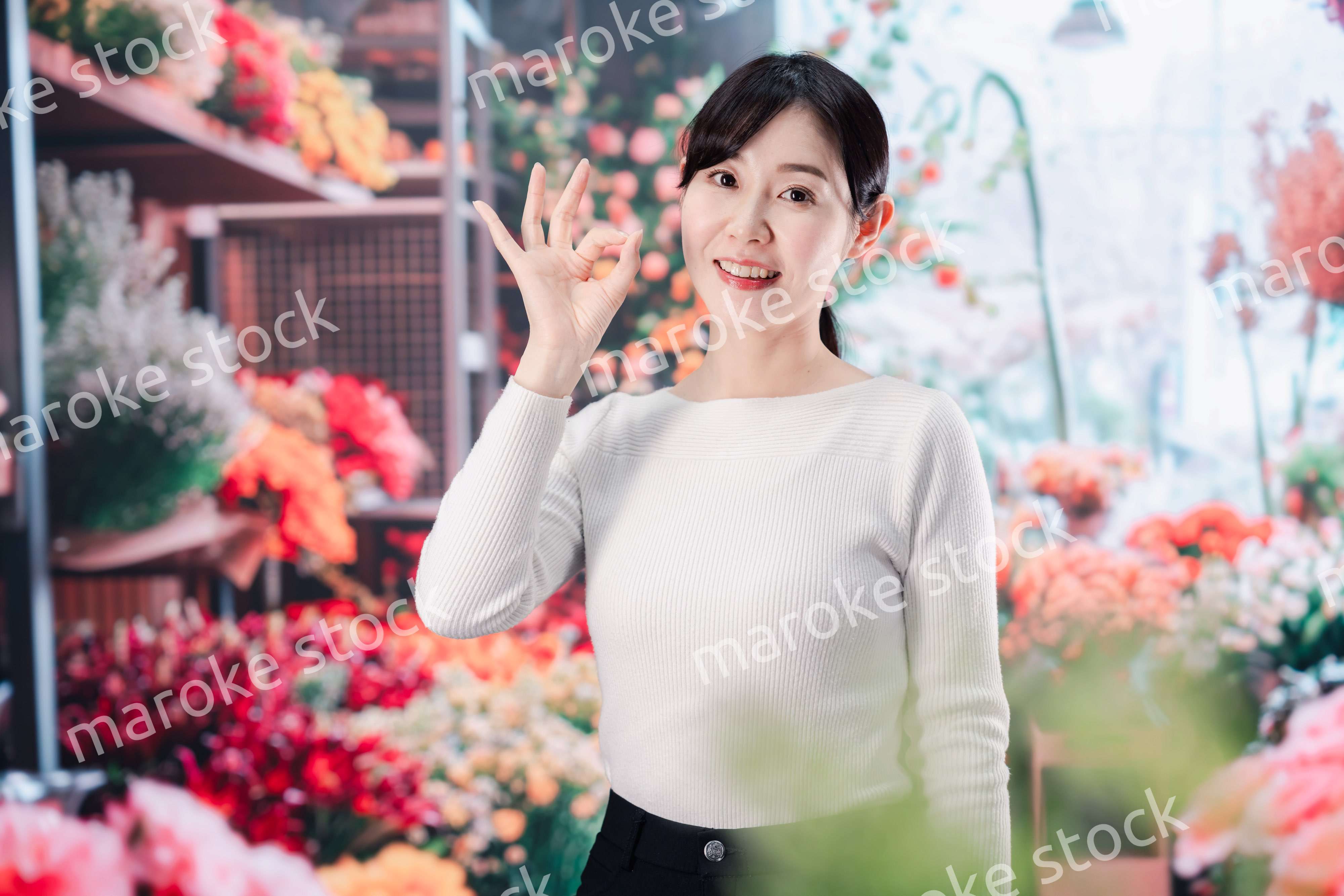 お花屋さんで花を選ぶ若い女性