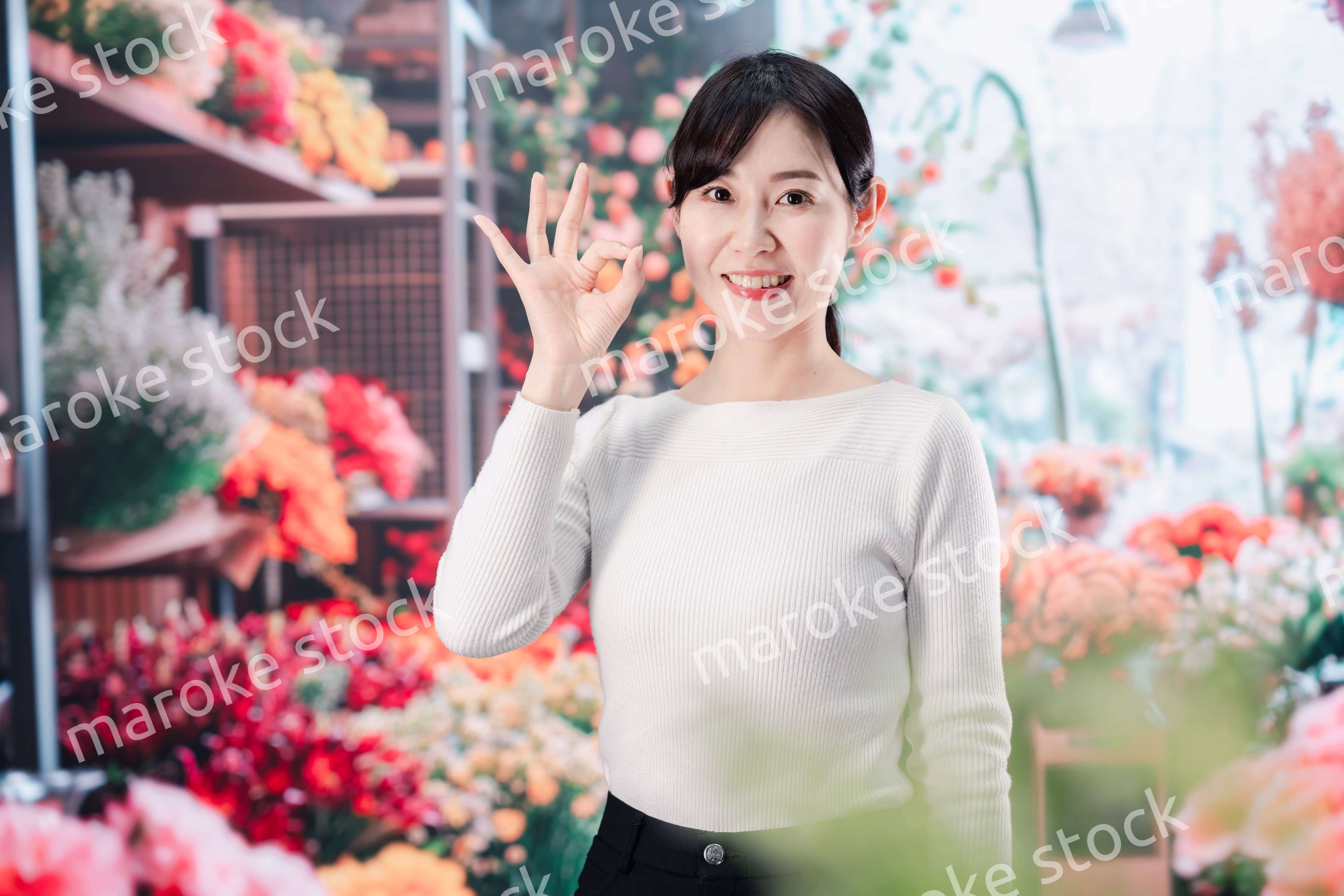 お花屋さんで花を選ぶ若い女性