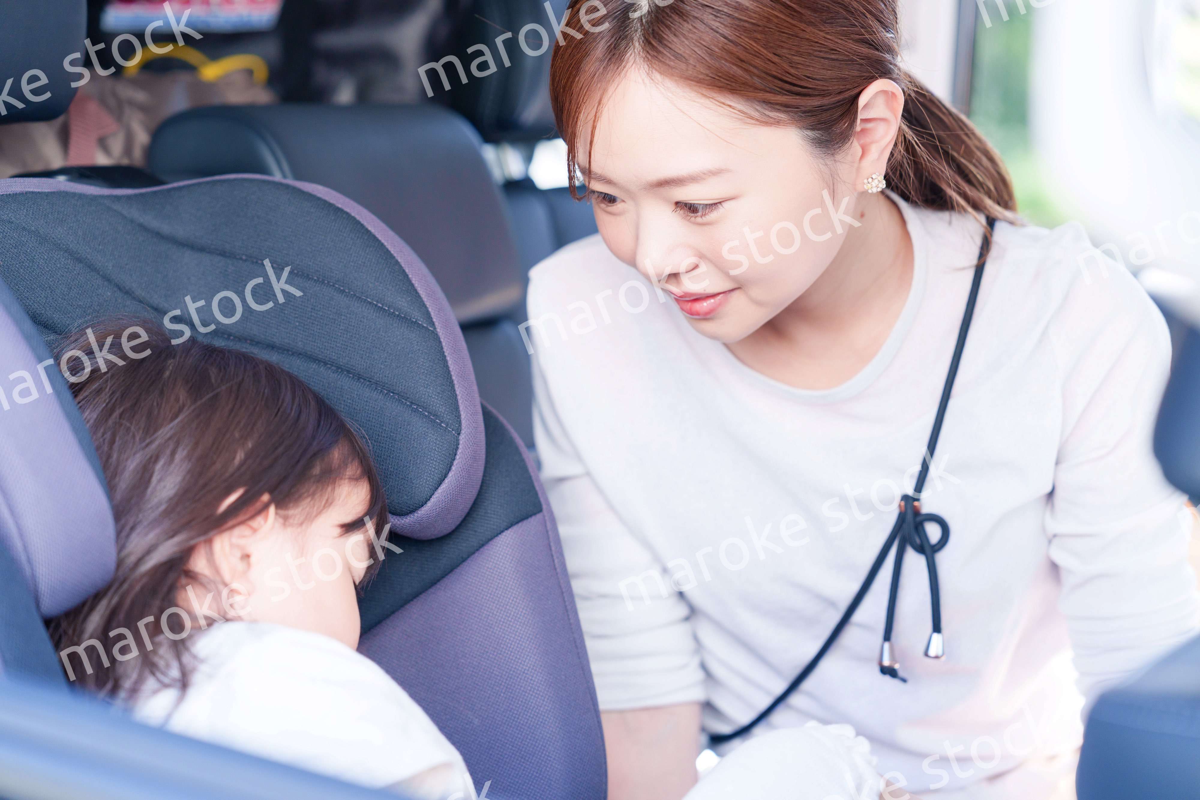 車でお出かけをする小さな子供とお母さん