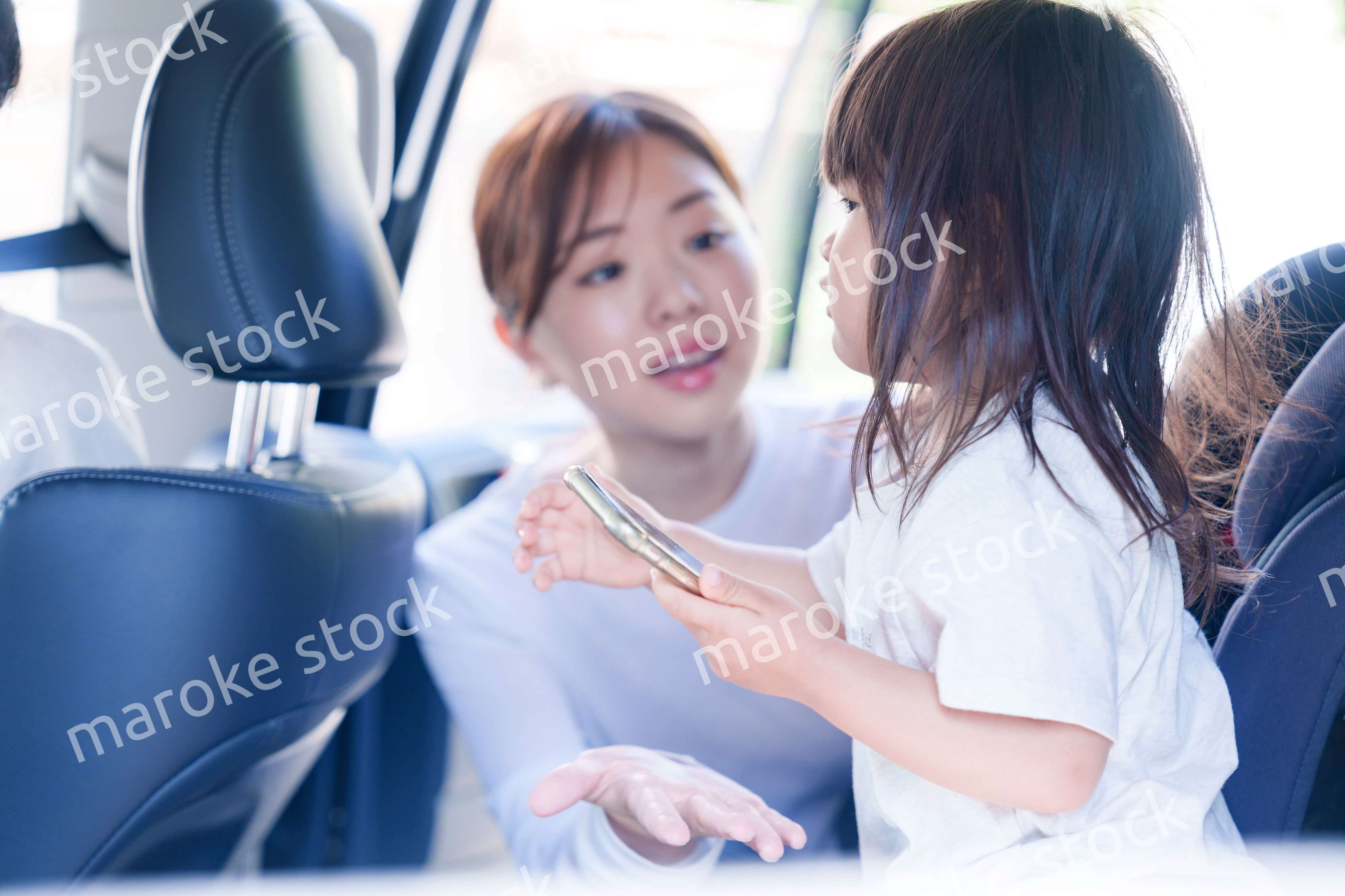 車でお出かけをする小さな子供とお母さん