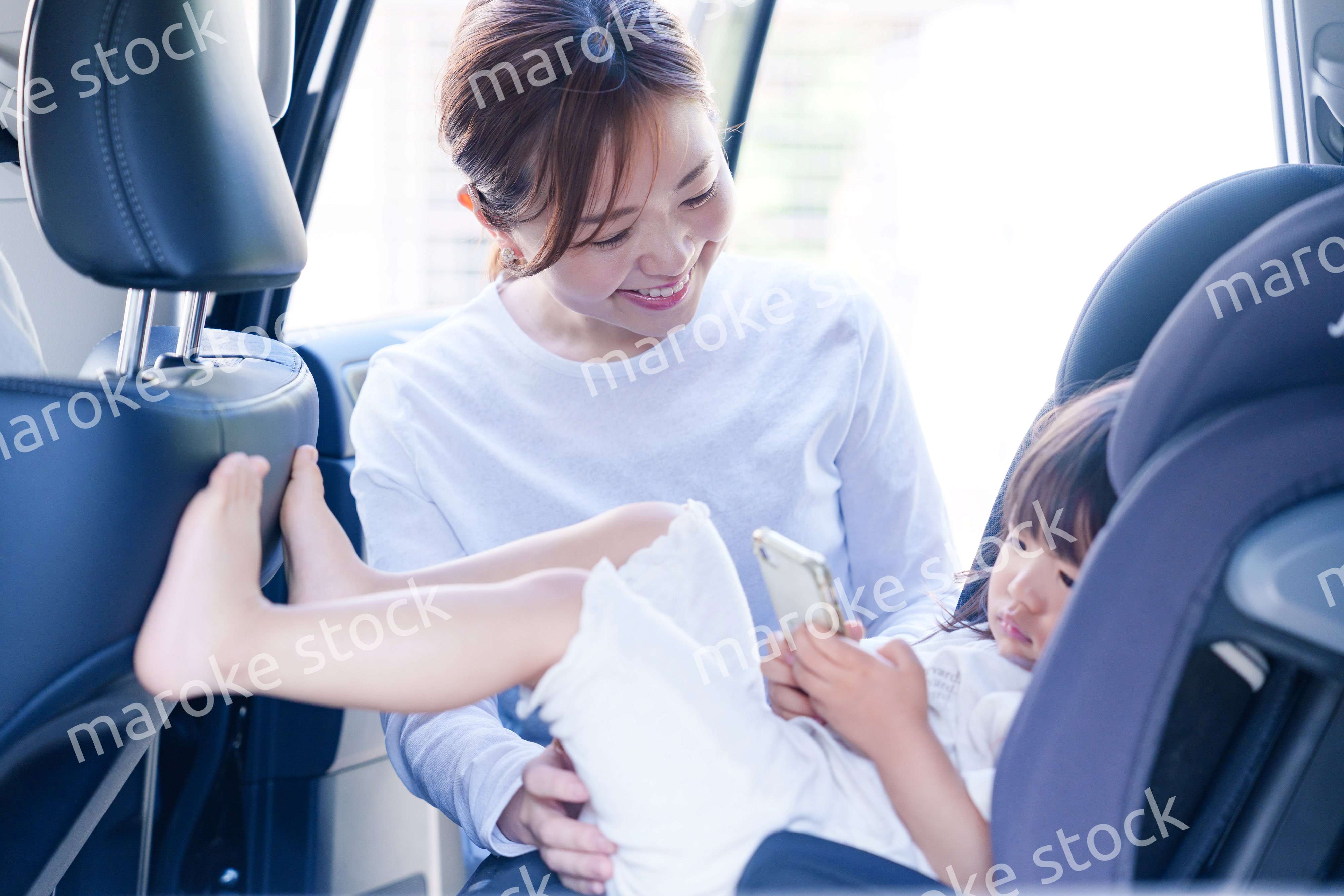 車でお出かけをする小さな子供とお母さん