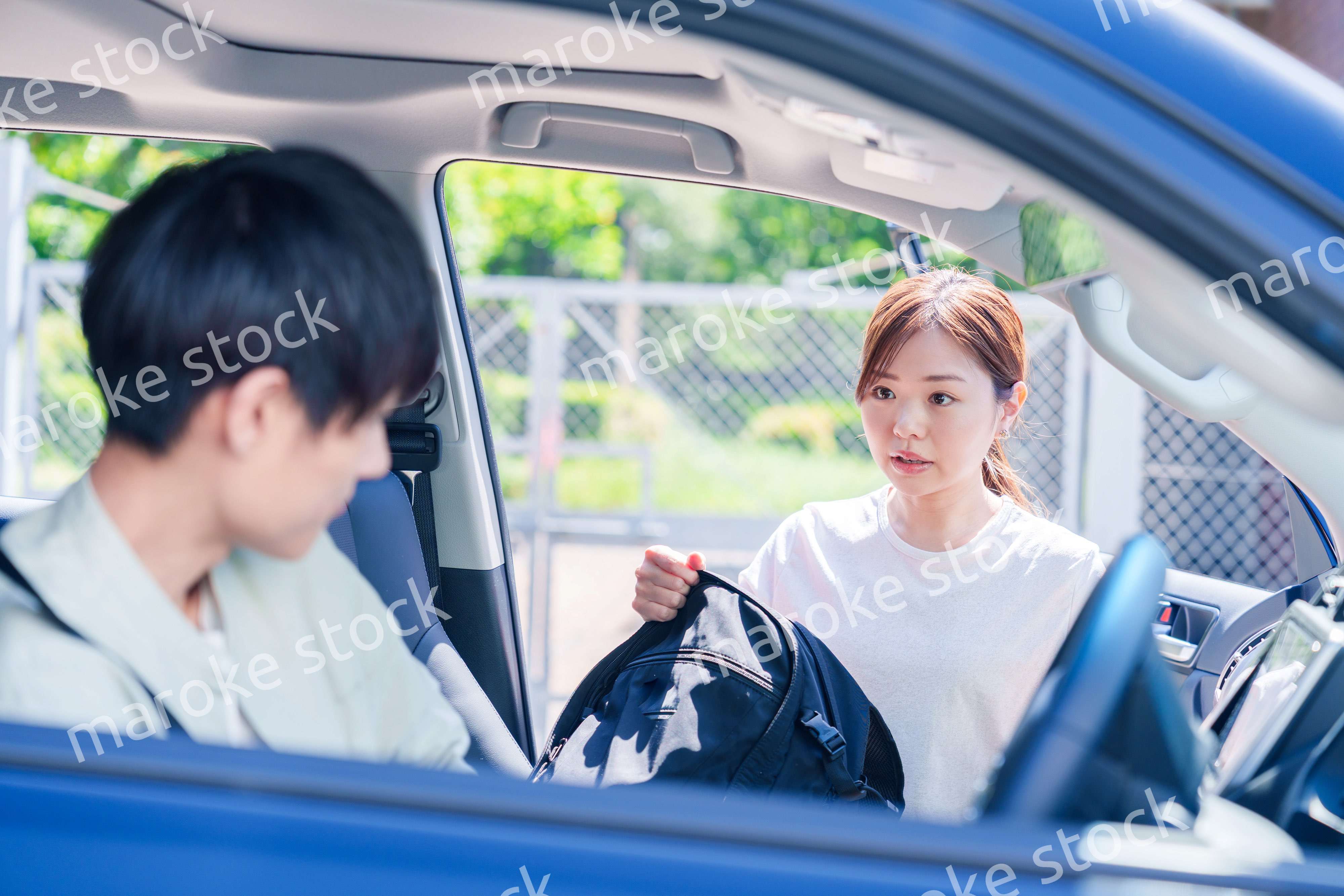 車で妻を送る若い夫