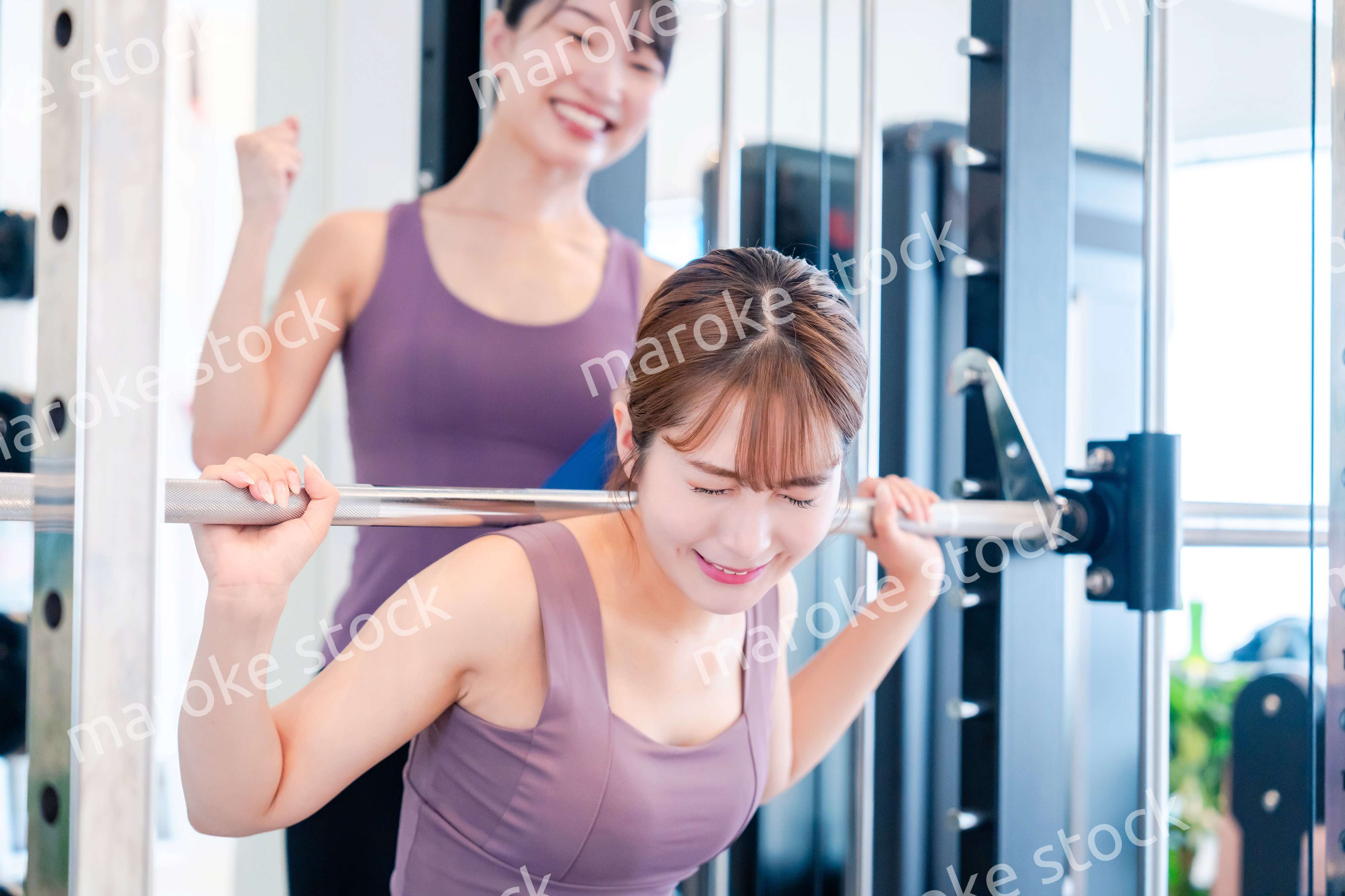 ジムで女性コーチのパーソナルトレーニングを受ける女性