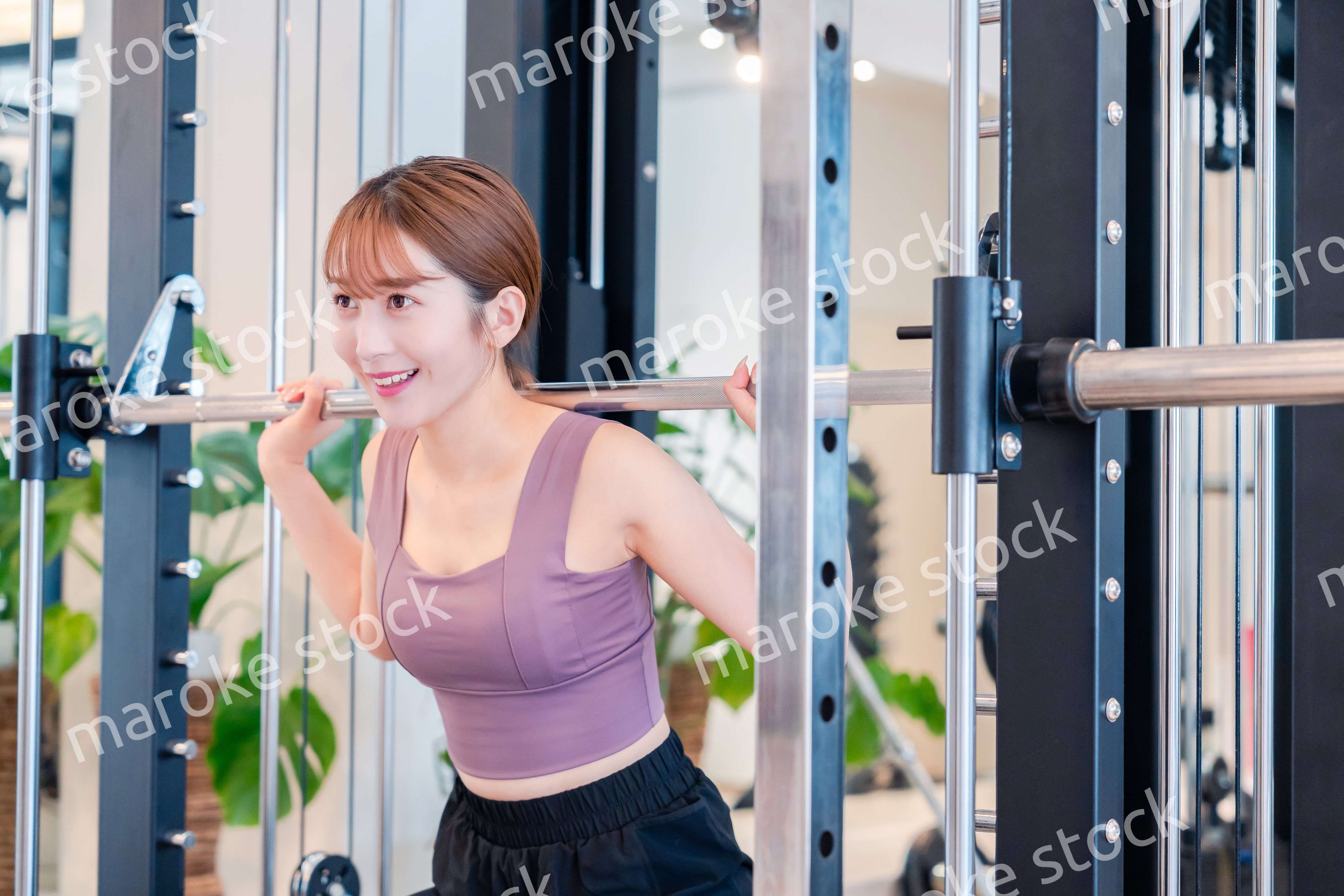 ジムで筋トレをするスポーティーな若い女性