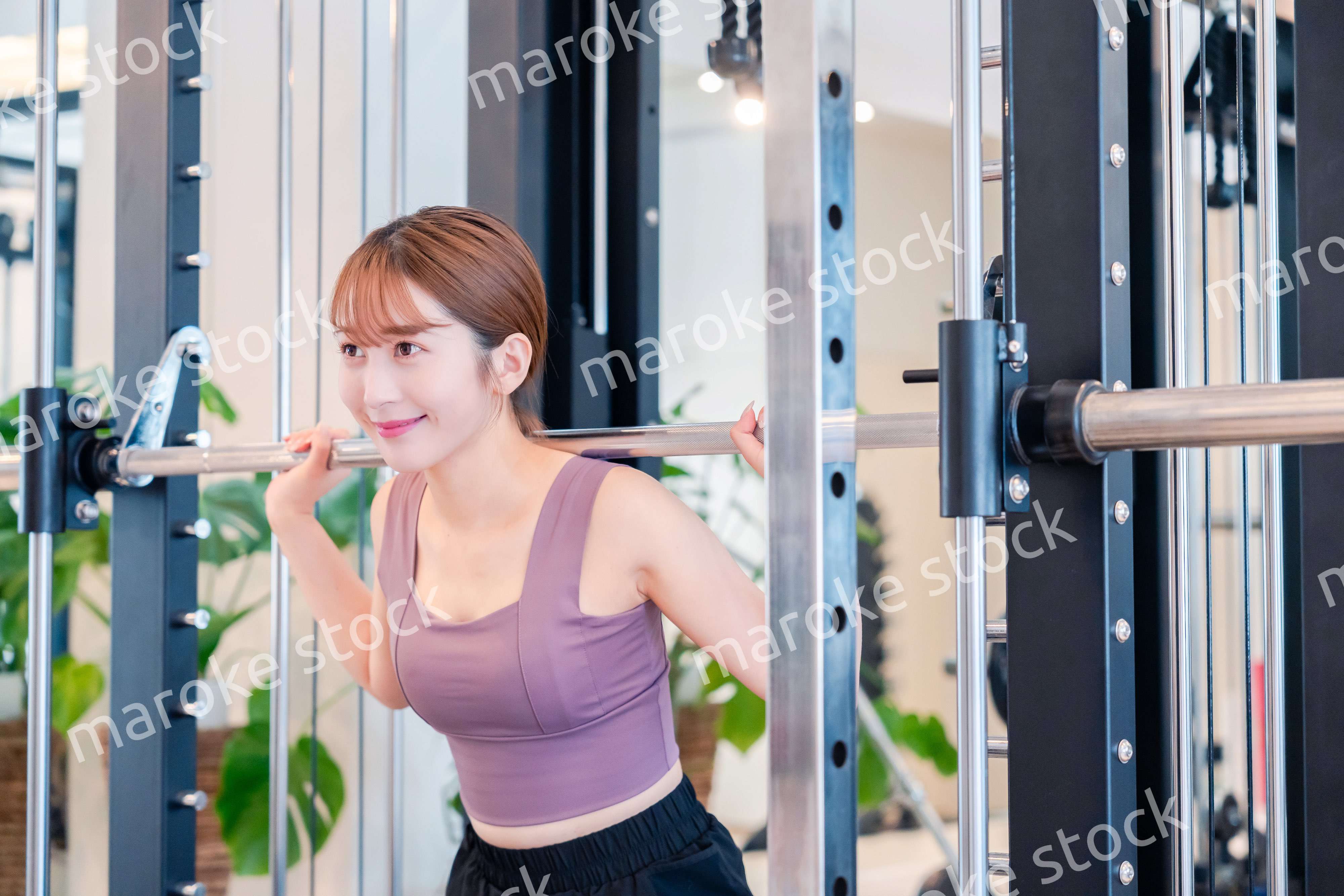 ジムで筋トレをするスポーティーな若い女性