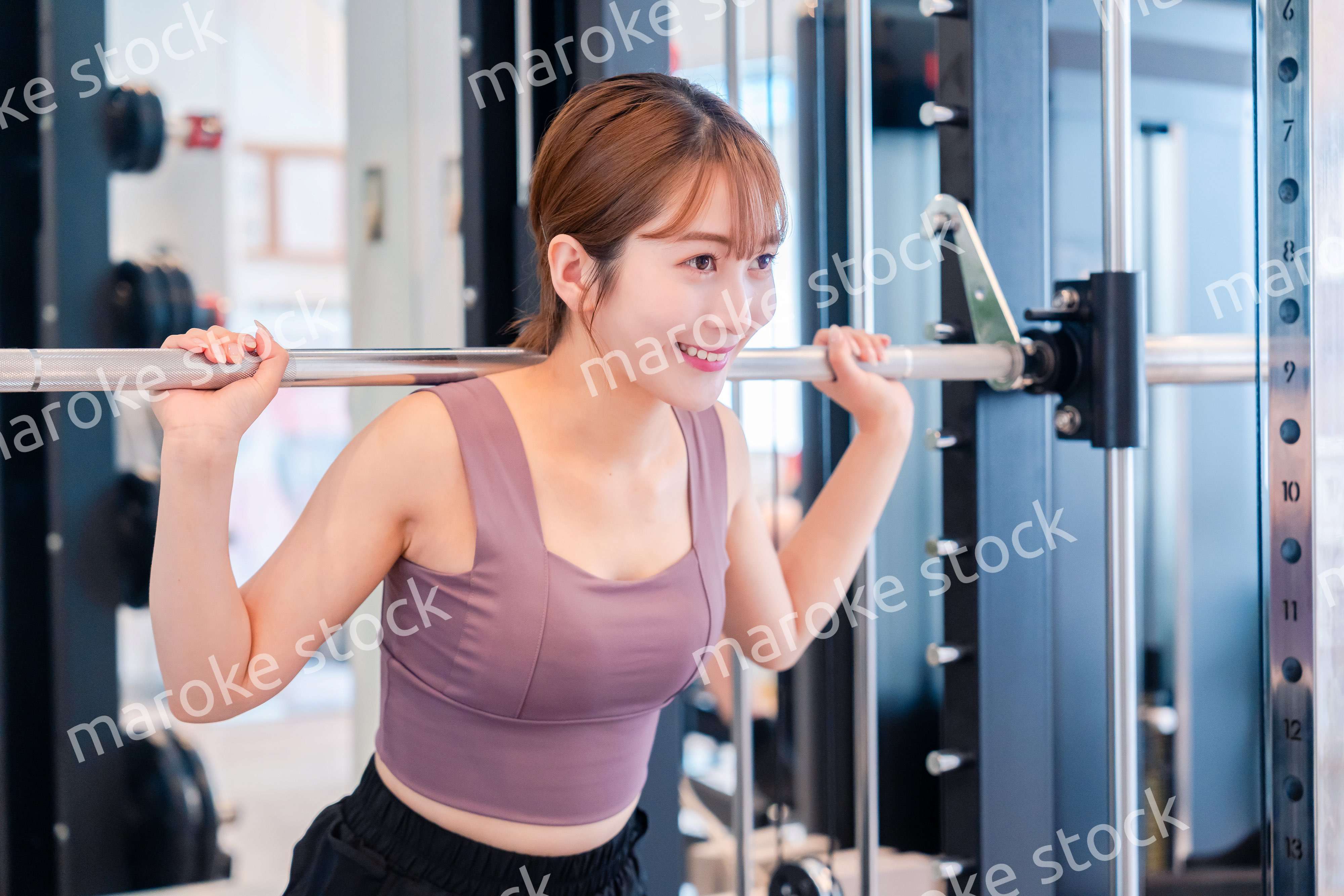 ジムで筋トレをするスポーティーな若い女性