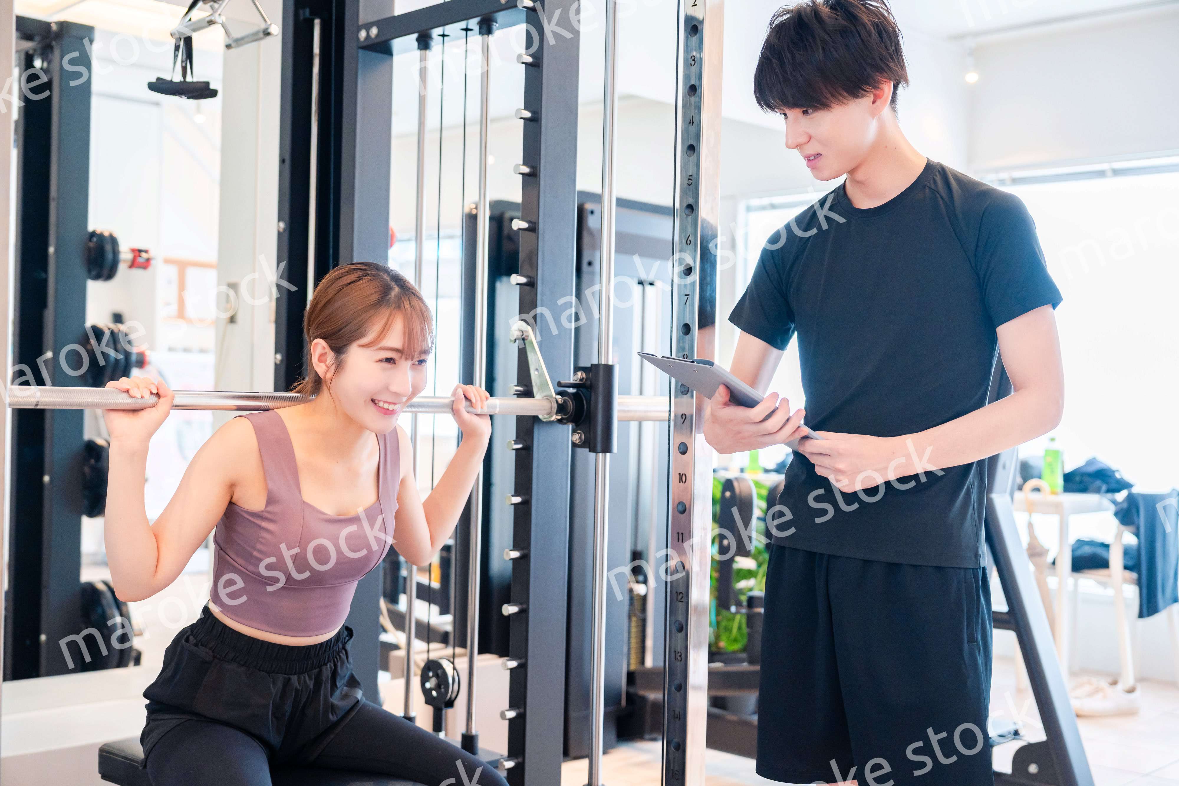 パーソナルジムに通う女性とトレーナー