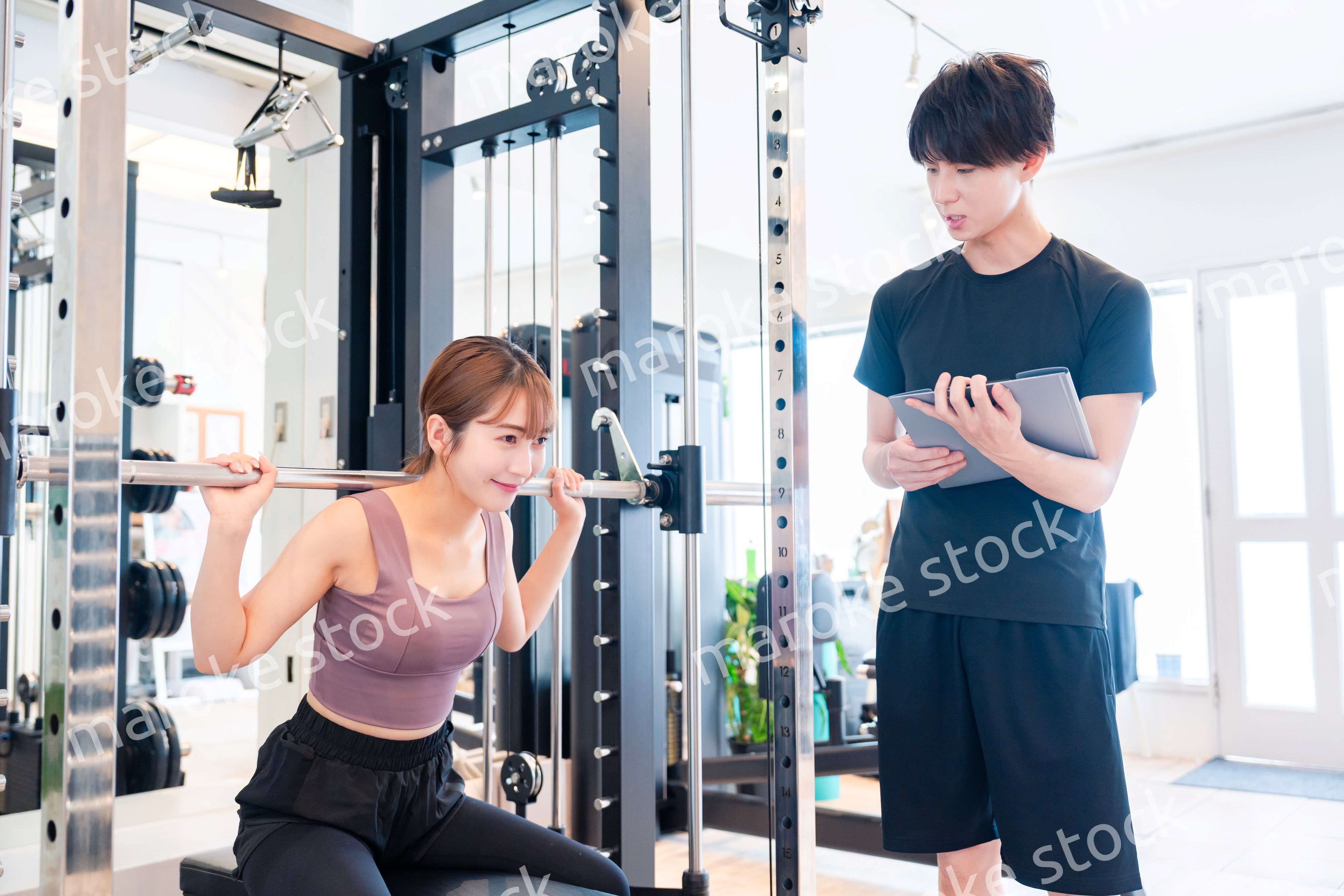パーソナルジムに通う女性とトレーナー
