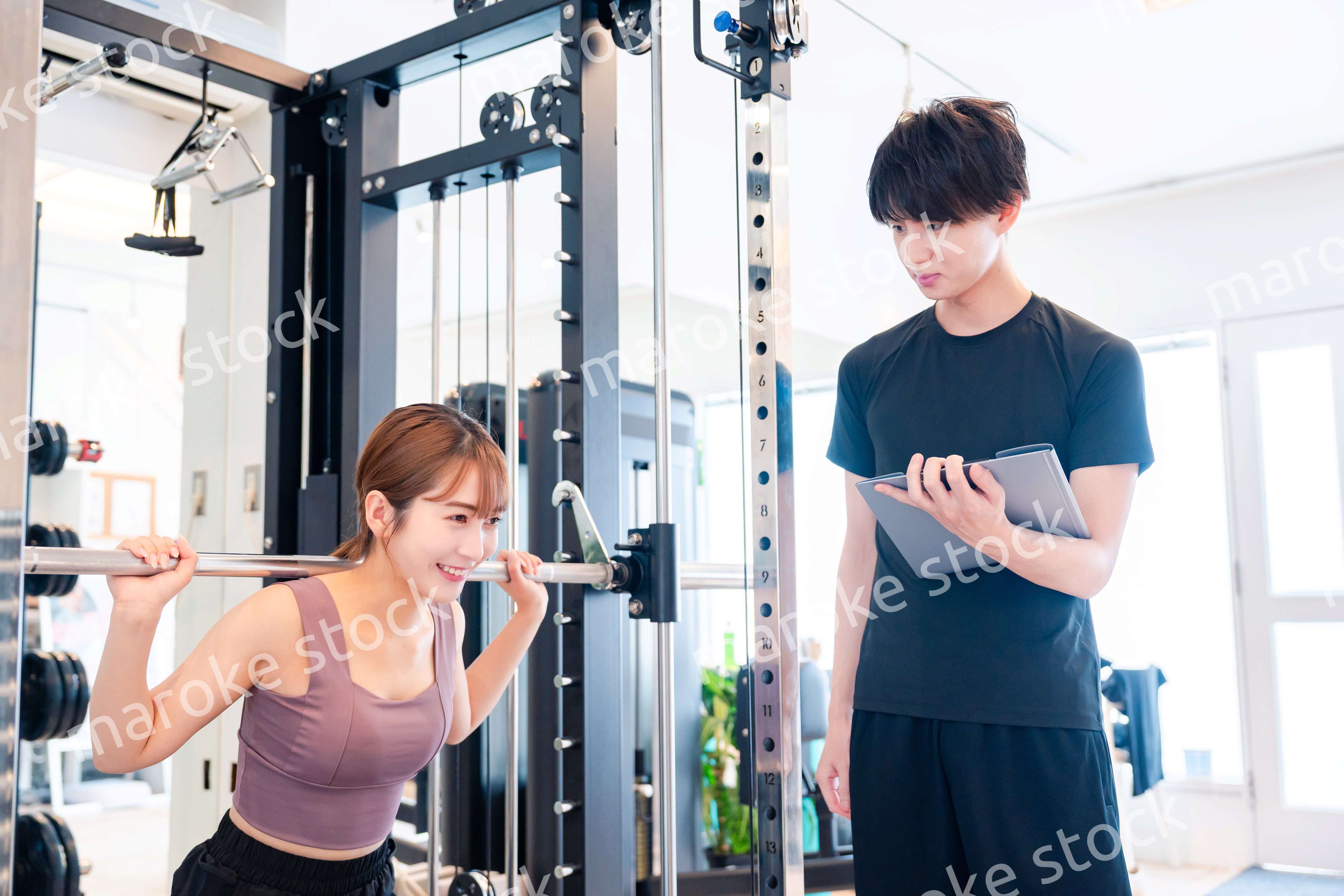 パーソナルジムに通う女性とトレーナー