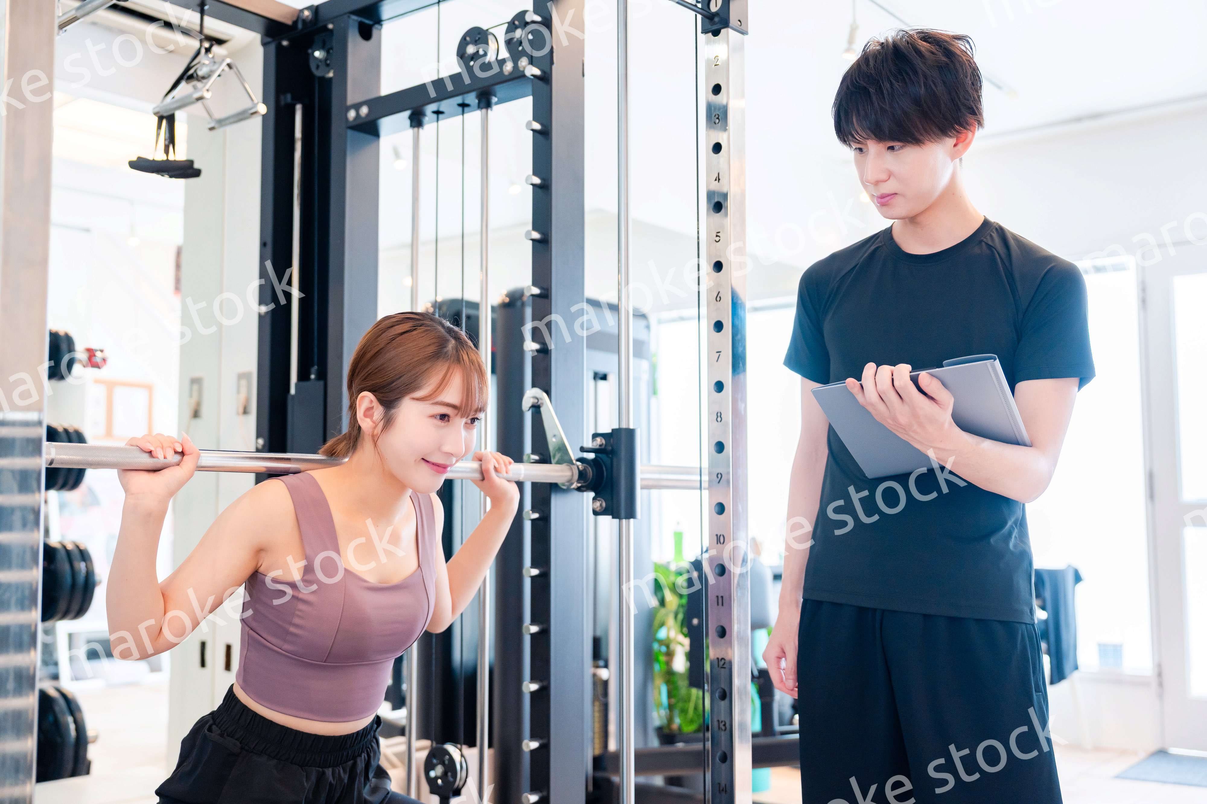 パーソナルジムに通う女性とトレーナー