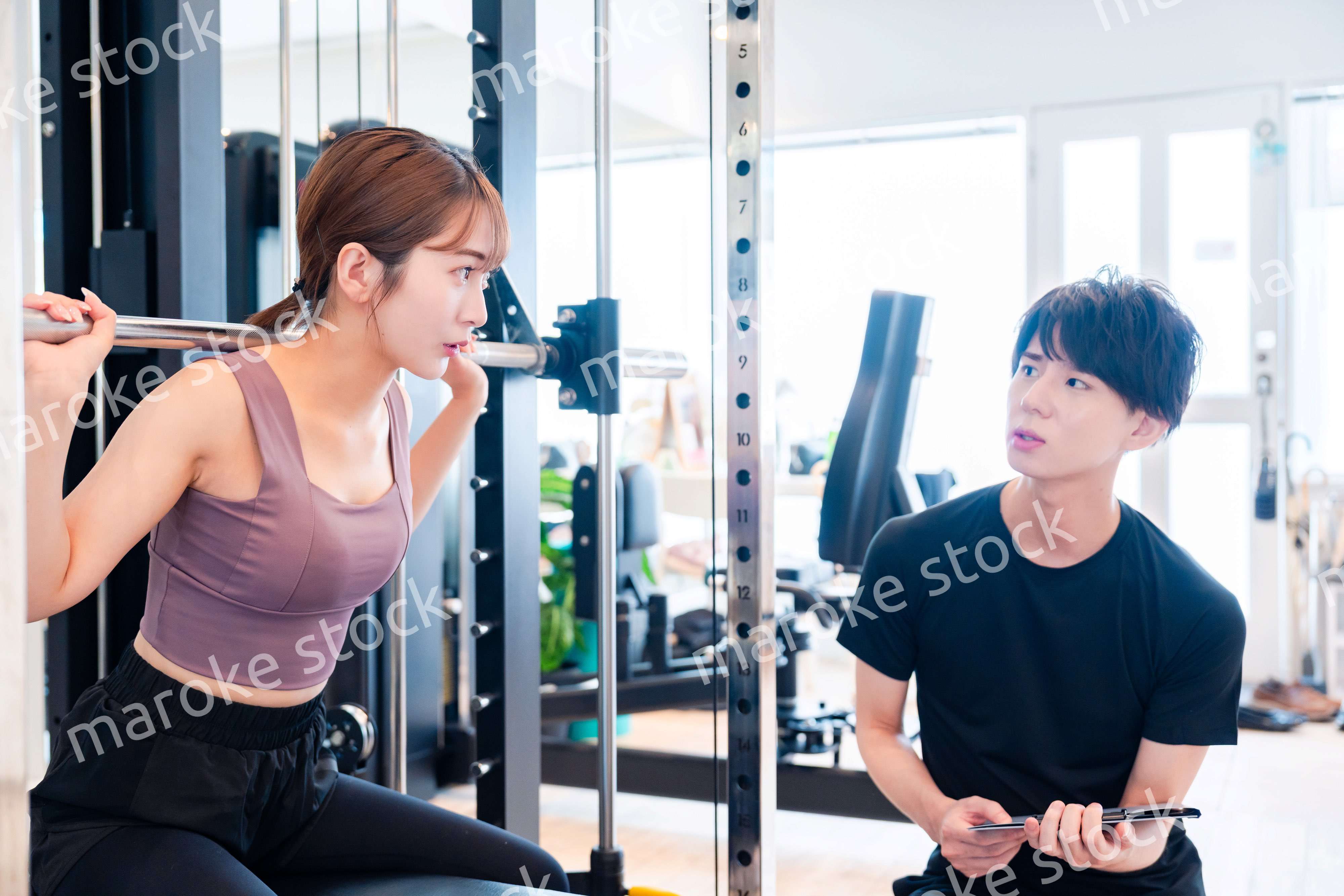 パーソナルジムに通う女性とトレーナー