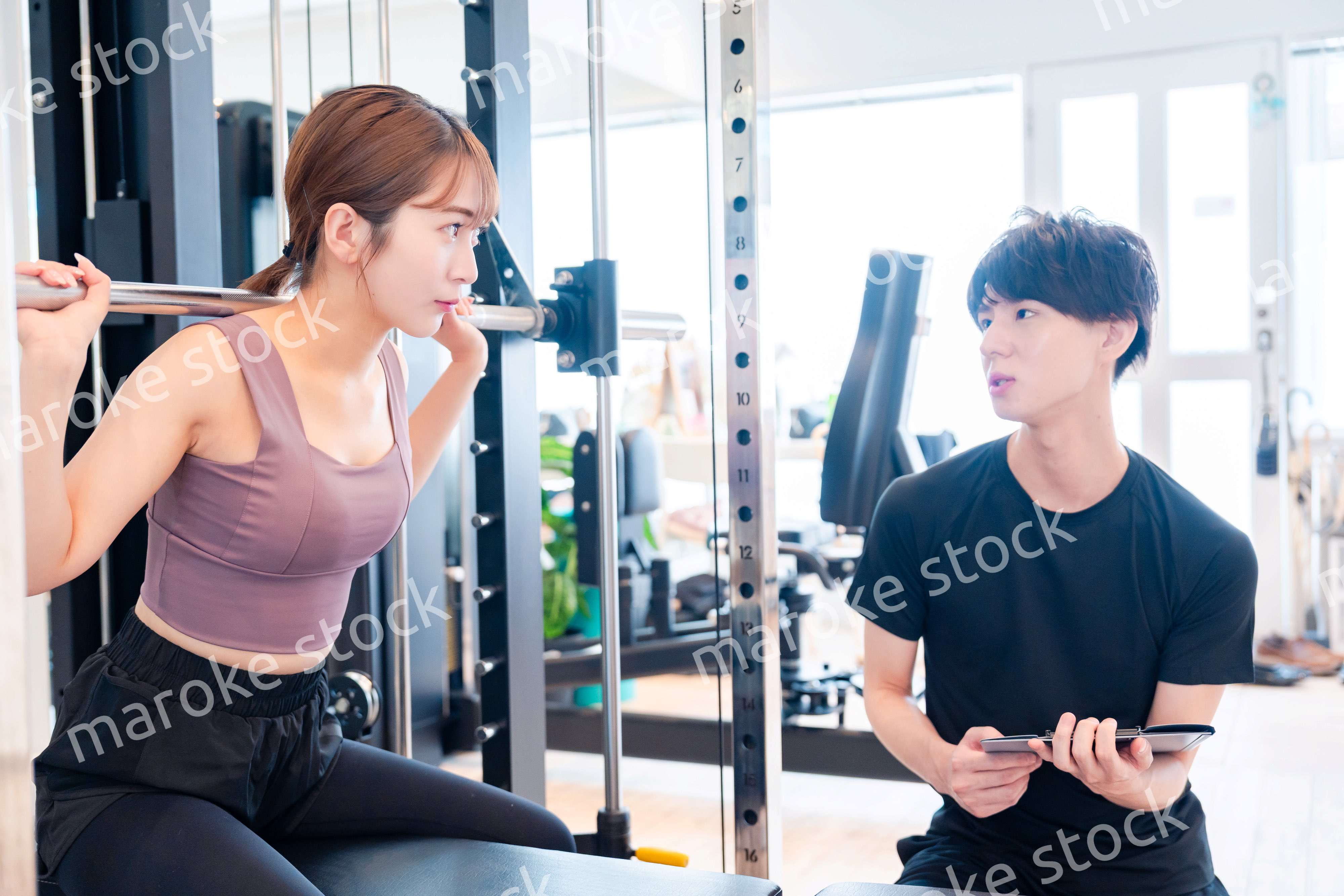 パーソナルジムに通う女性とトレーナー