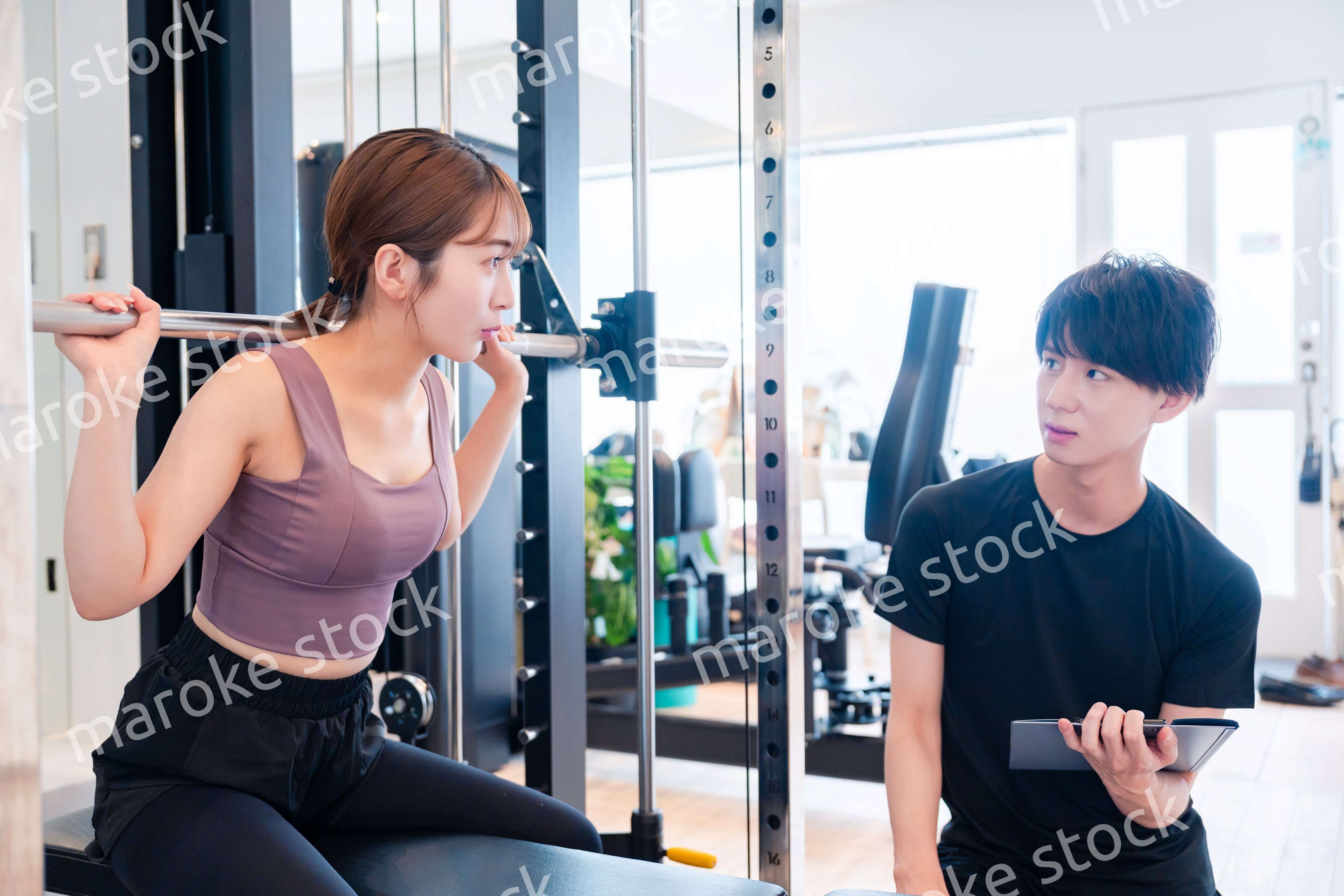 パーソナルジムに通う女性とトレーナー