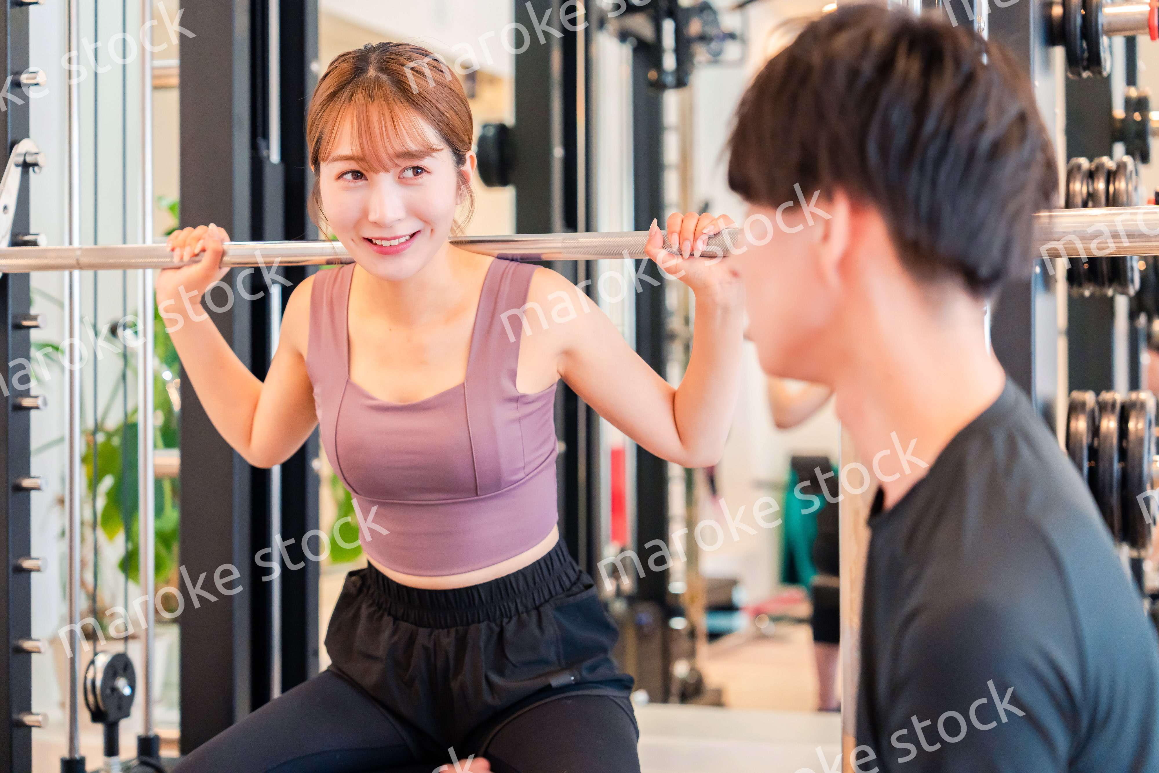 パーソナルジムに通う女性とトレーナー