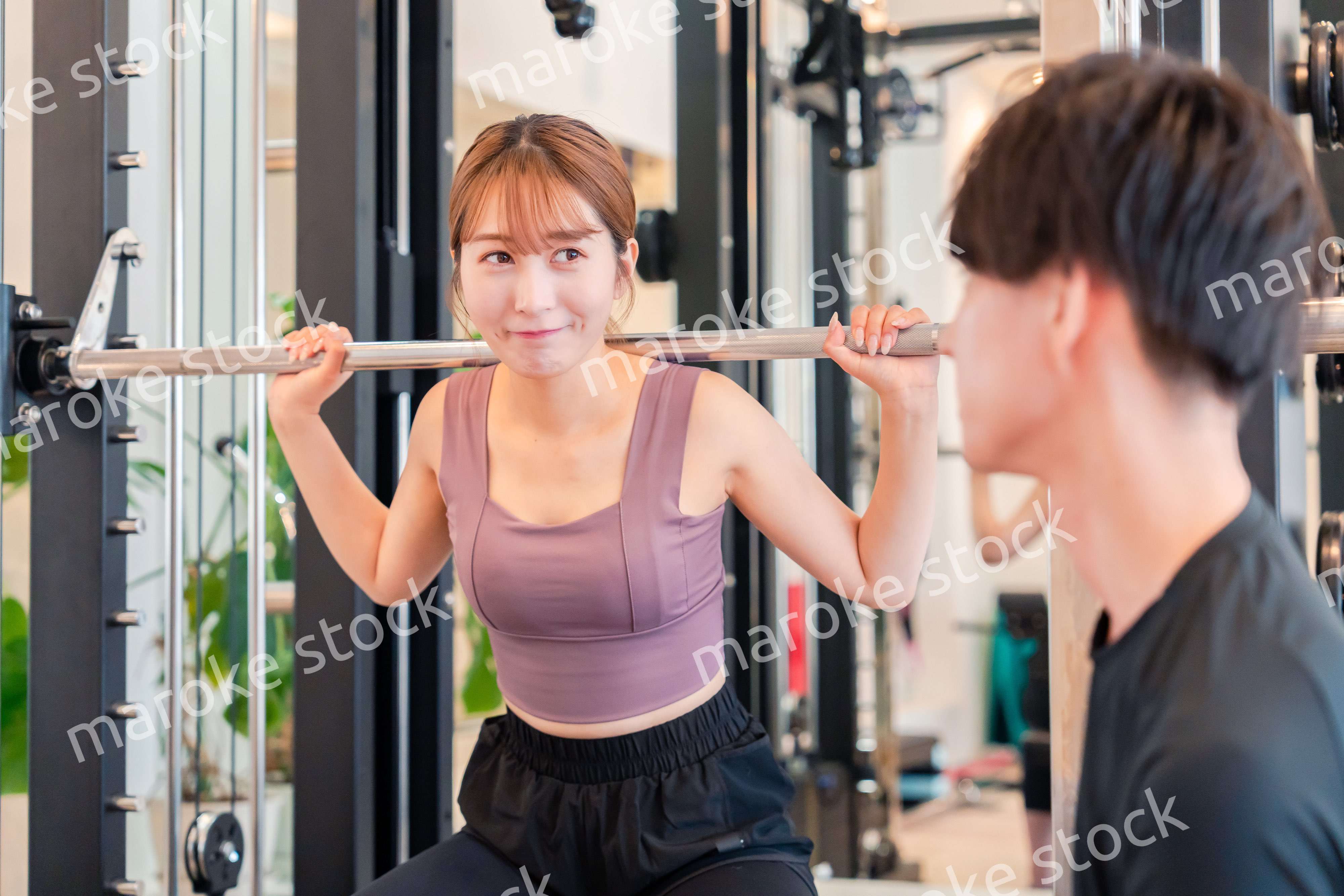 パーソナルジムに通う女性とトレーナー