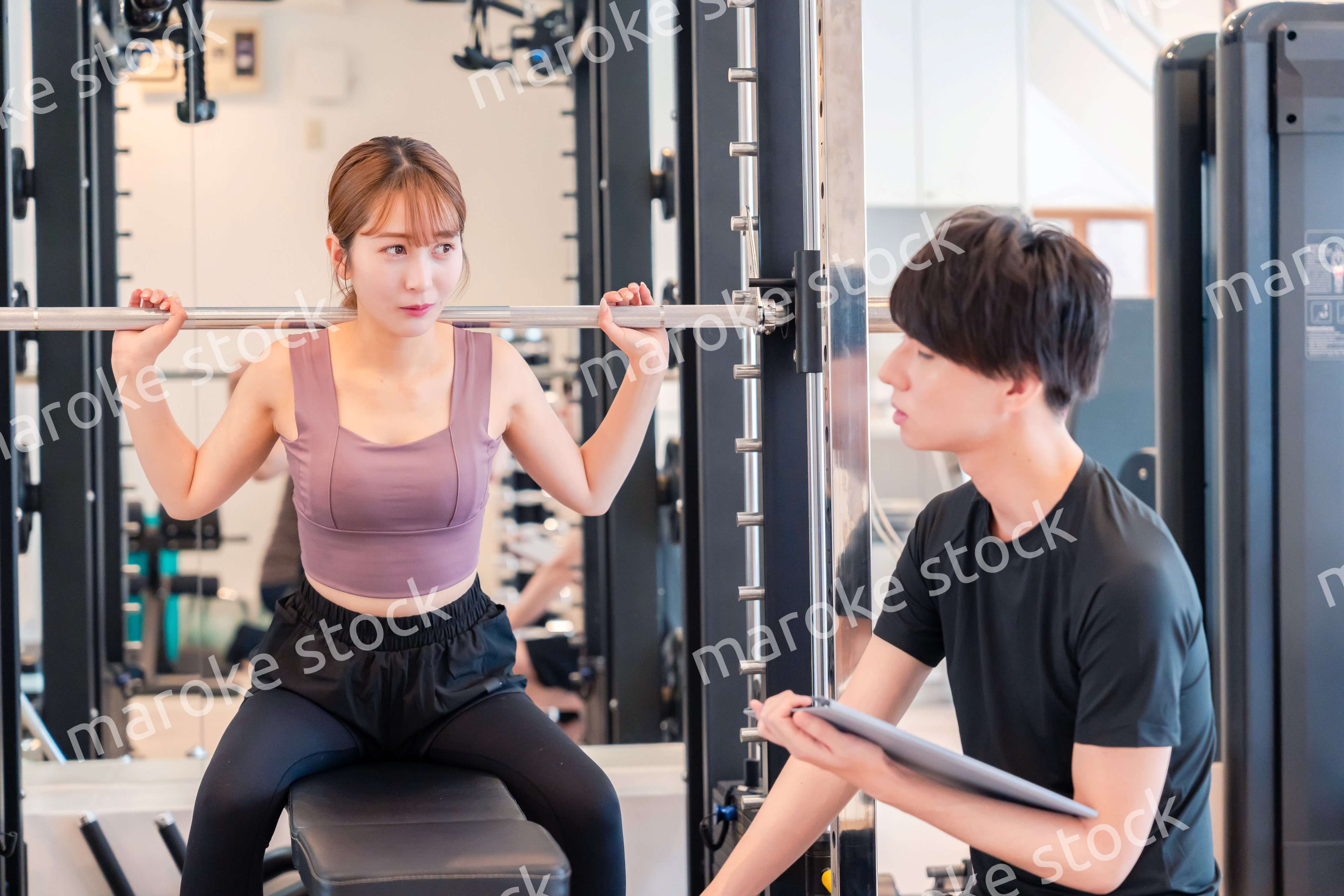 パーソナルジムに通う女性とトレーナー