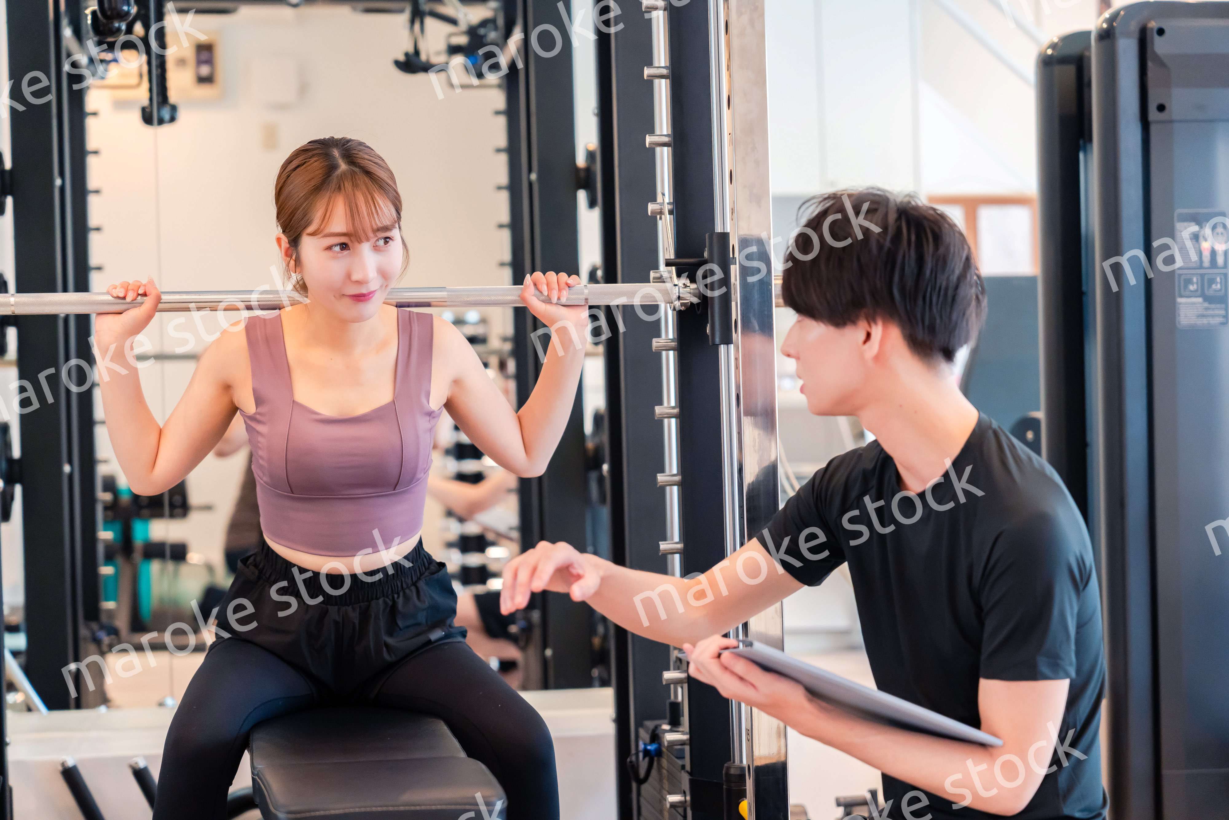 パーソナルジムに通う女性とトレーナー