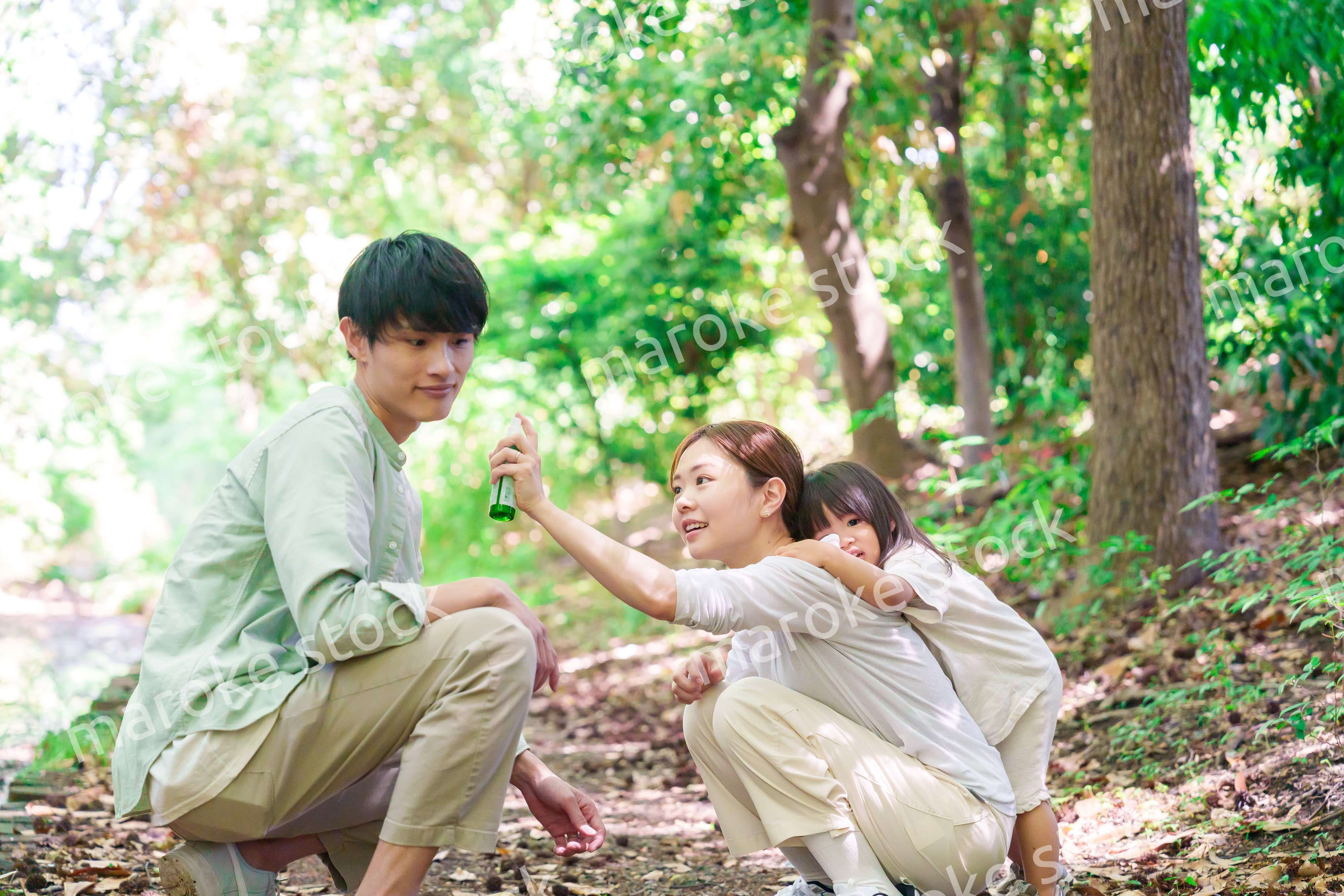 自然の中で虫除けスプレーを使うファミリー