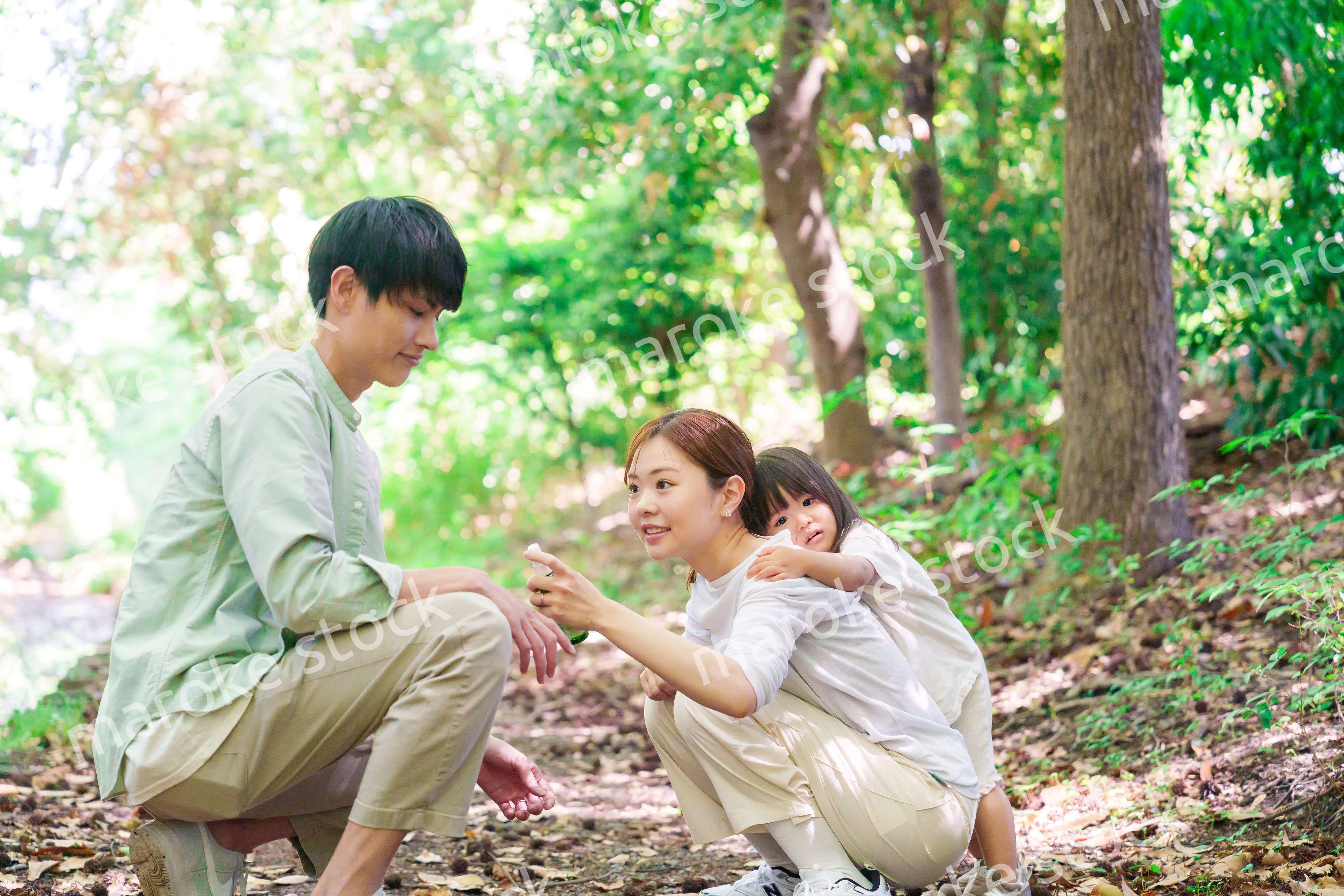 自然の中で虫除けスプレーを使うファミリー