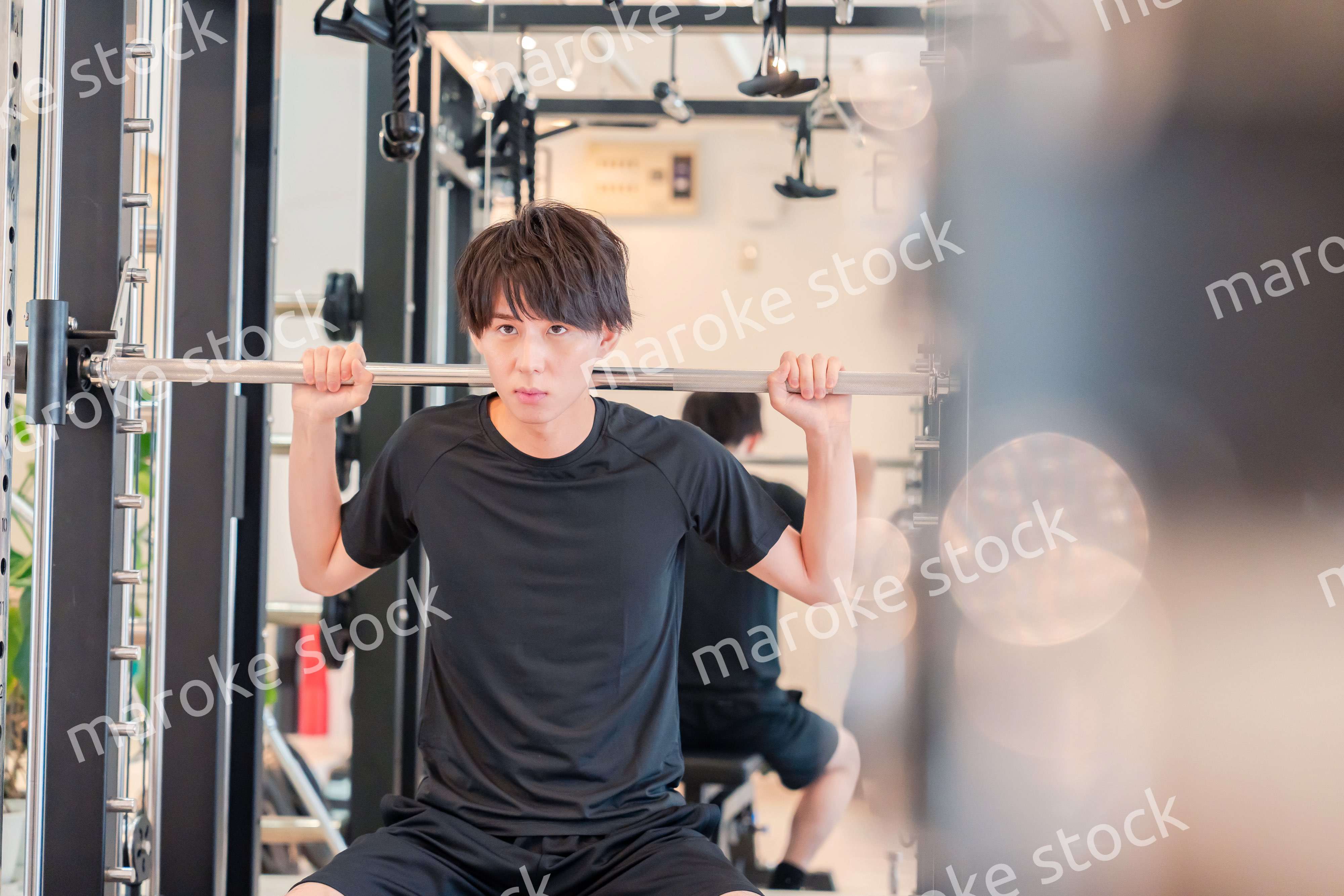 ジムで筋トレをする若い男性