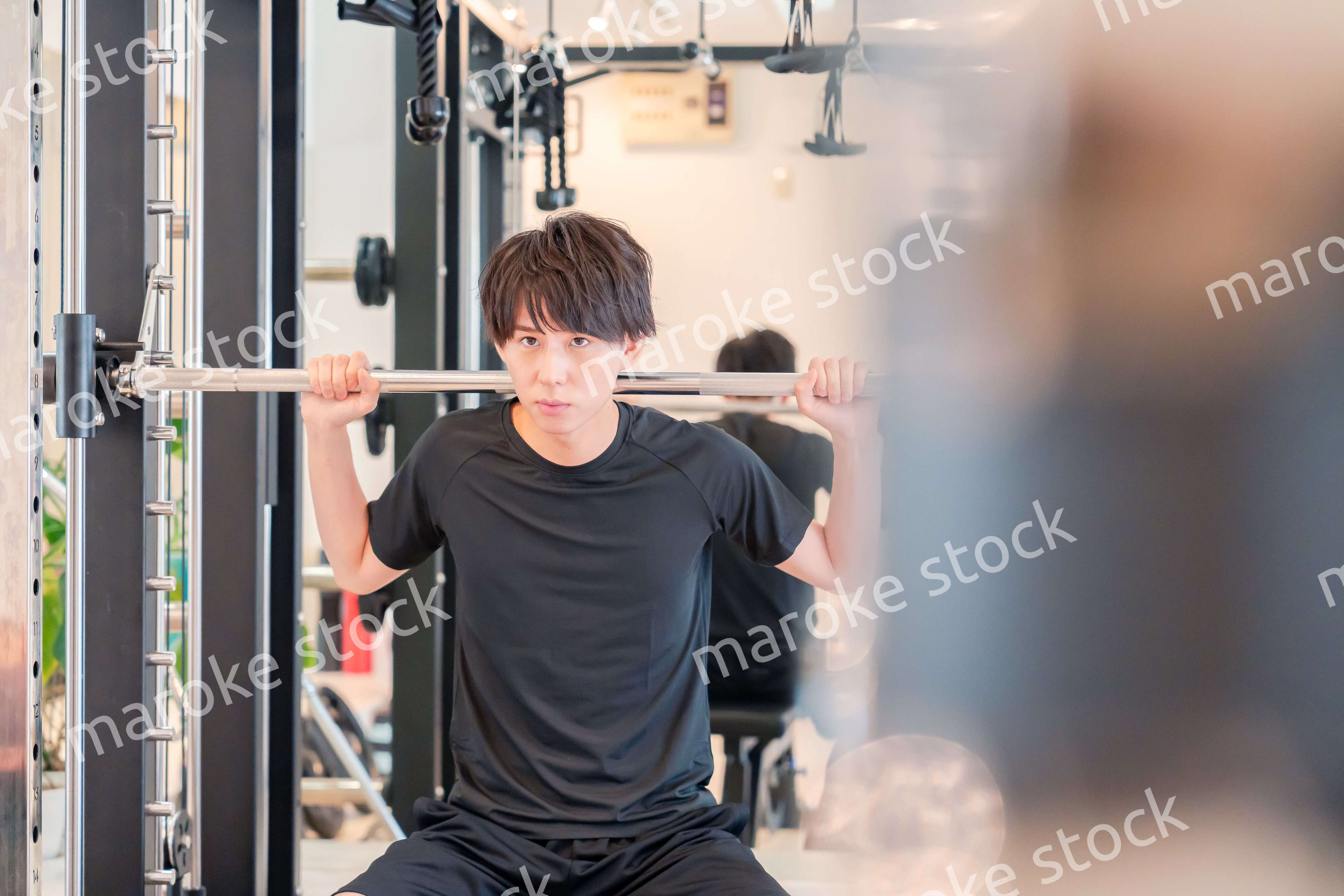 ジムで筋トレをする若い男性