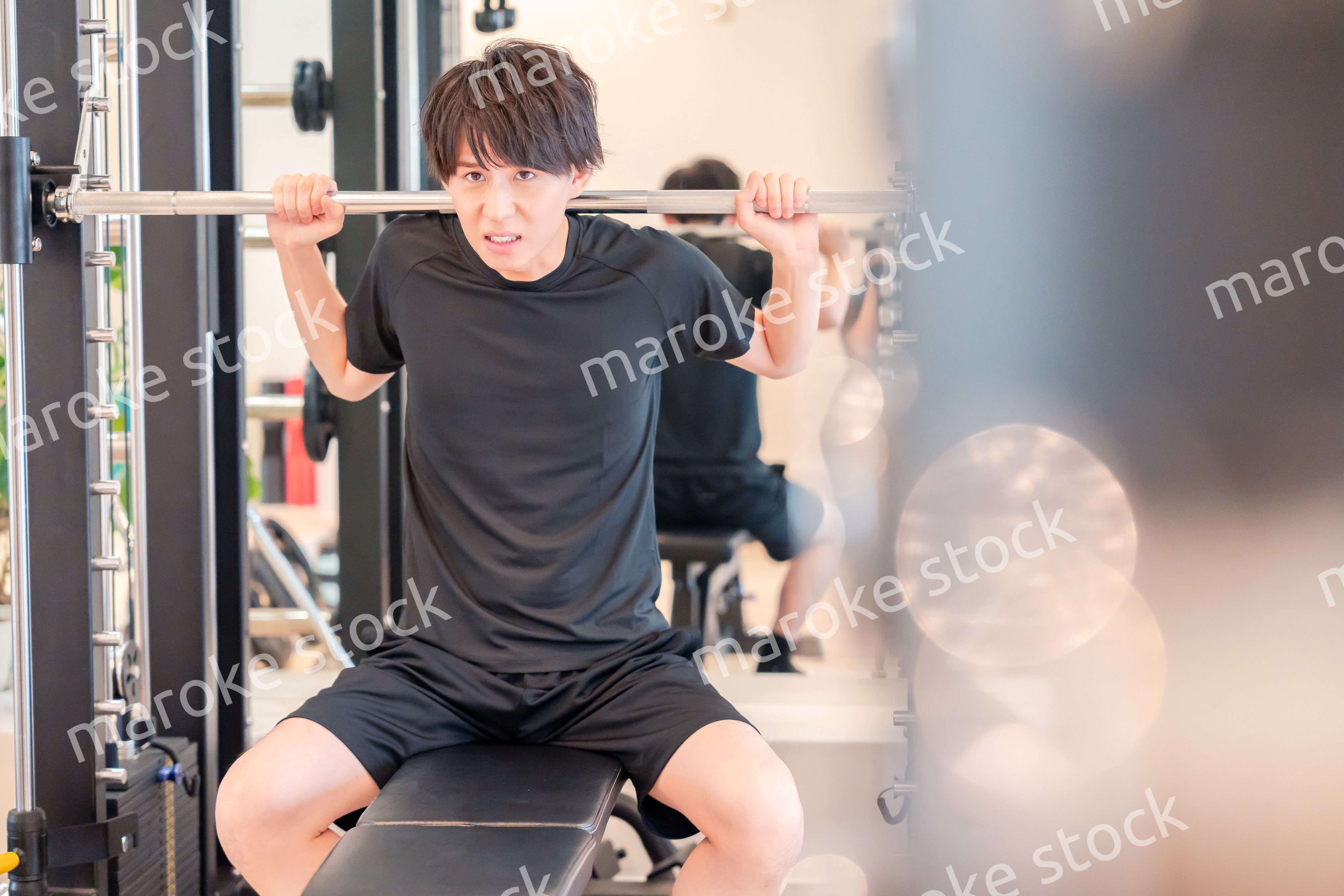 ジムで筋トレをする若い男性