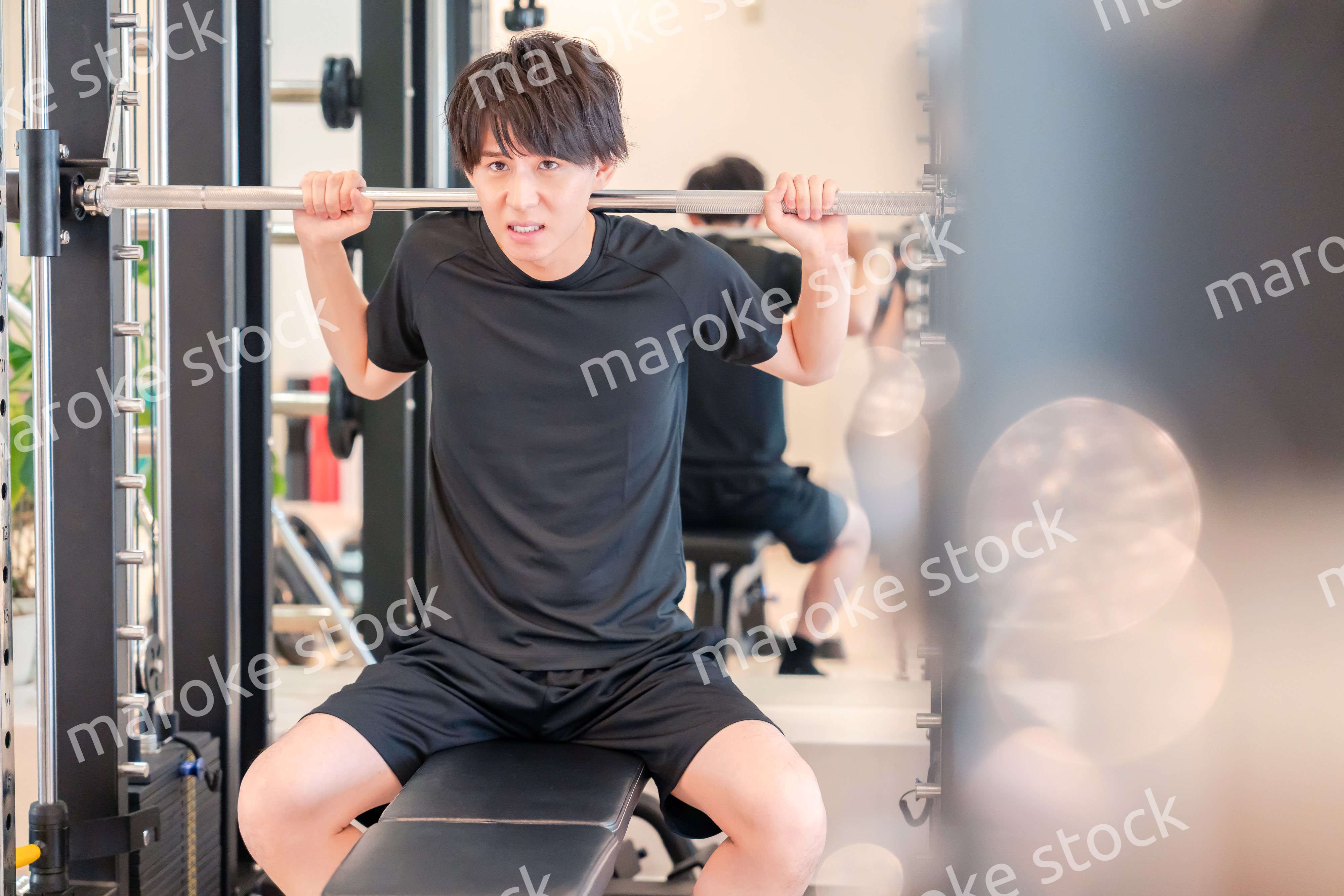 ジムで筋トレをする若い男性