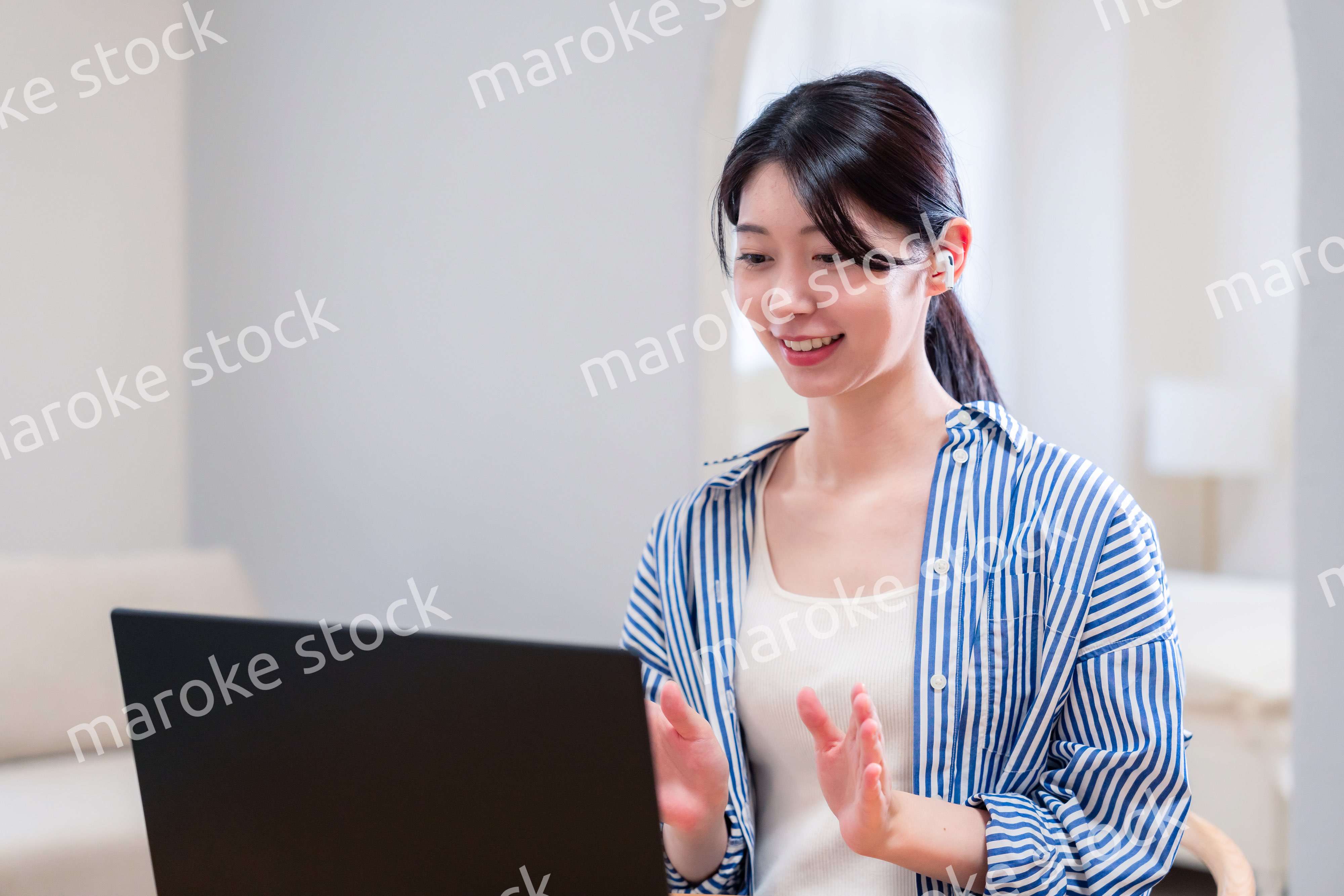 在宅でリモート会議に参加する若い女性社員