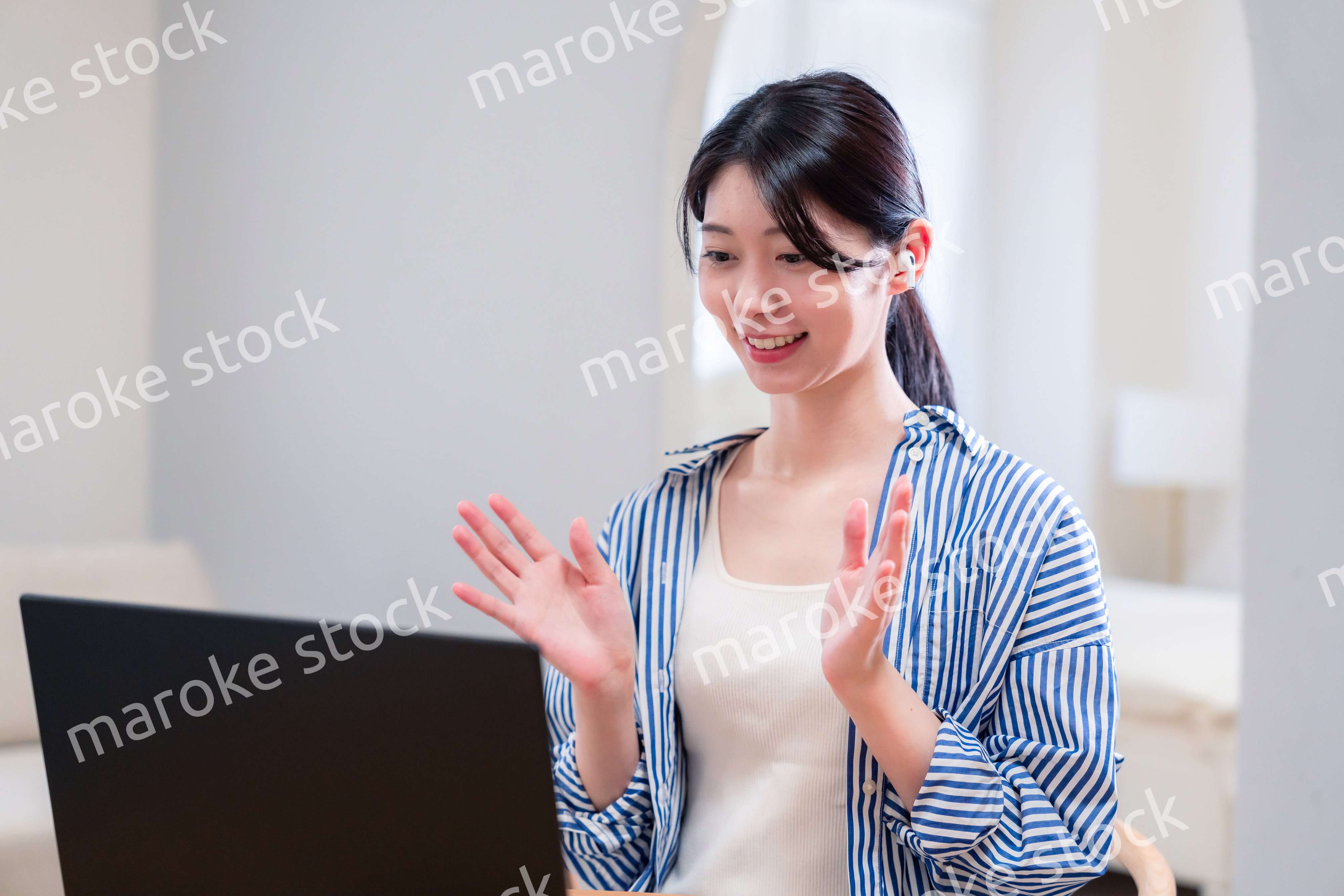 在宅でリモート会議に参加する若い女性社員