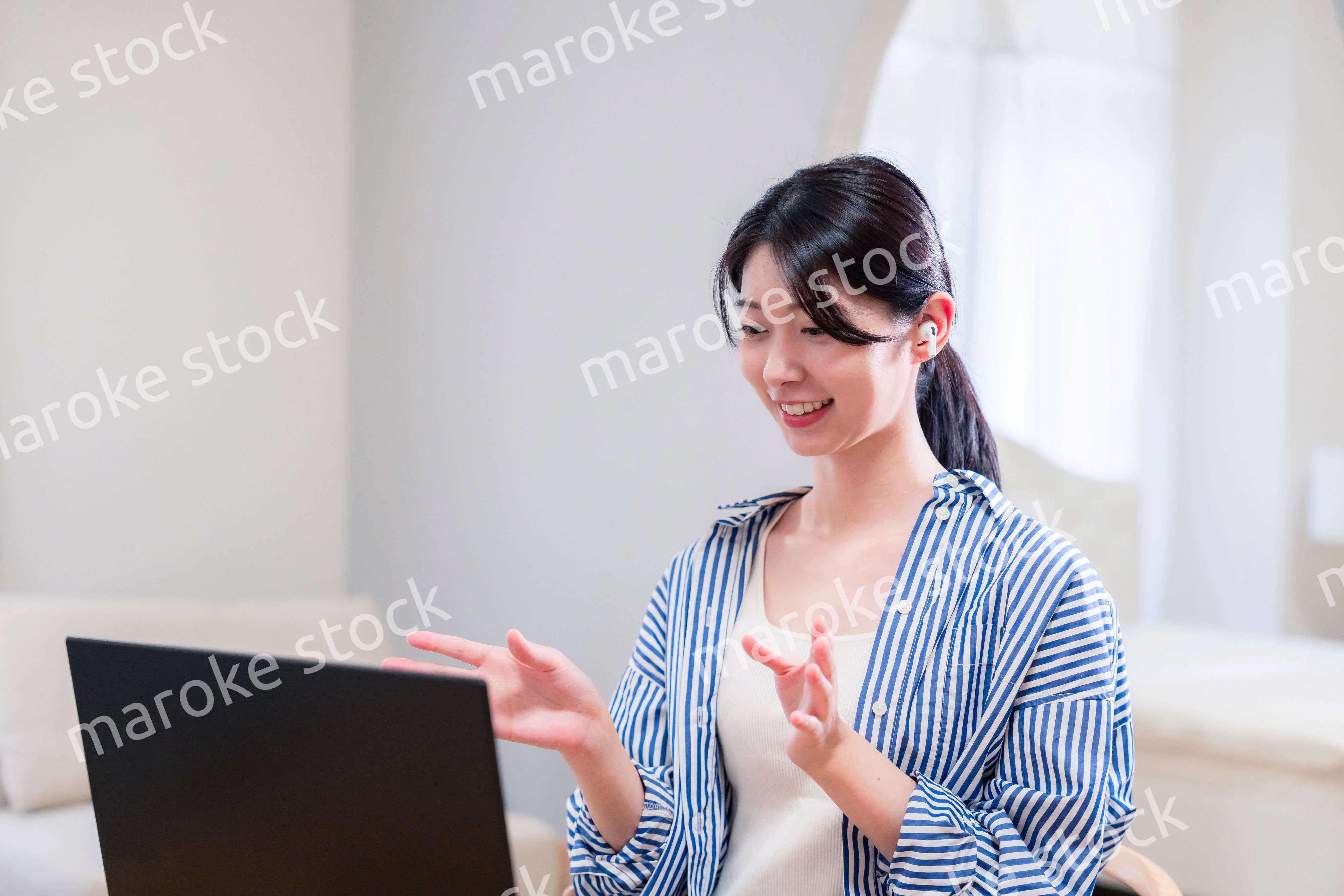 在宅でリモート会議に参加する若い女性社員