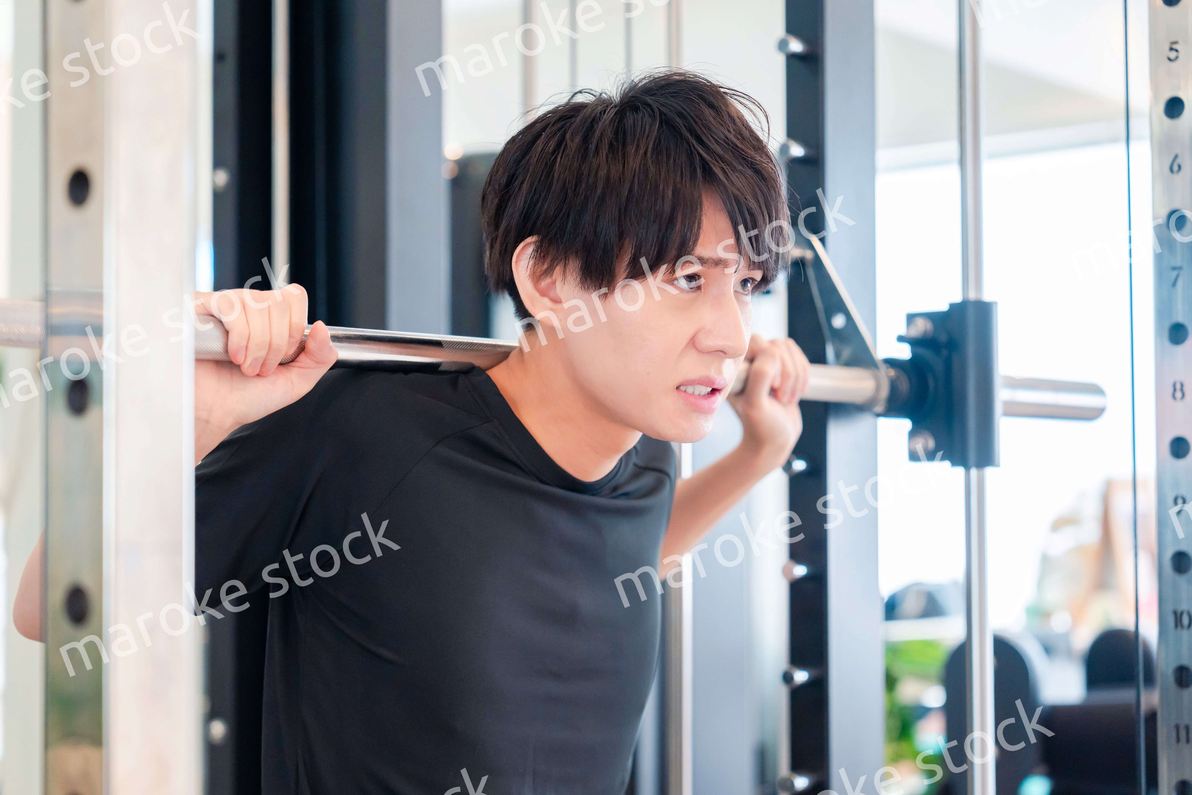 ジムで筋トレをする若い男性