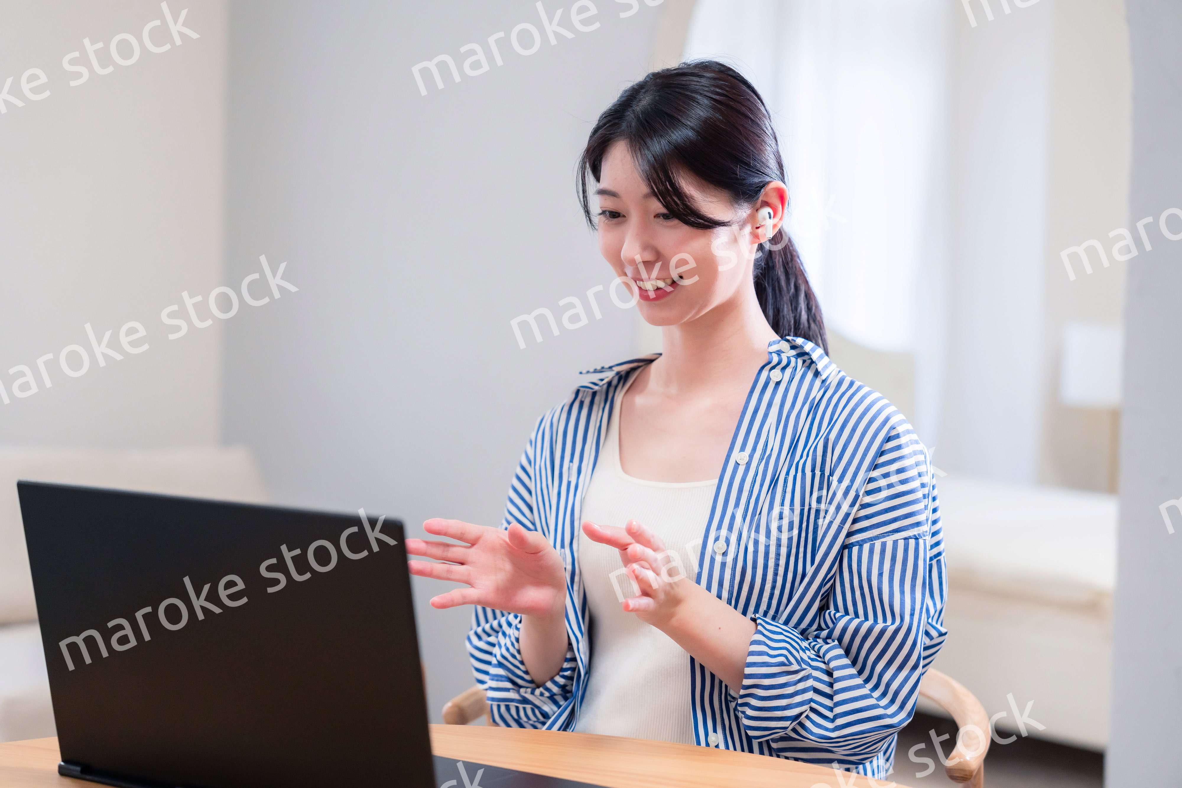 在宅でリモート会議に参加する若い女性社員