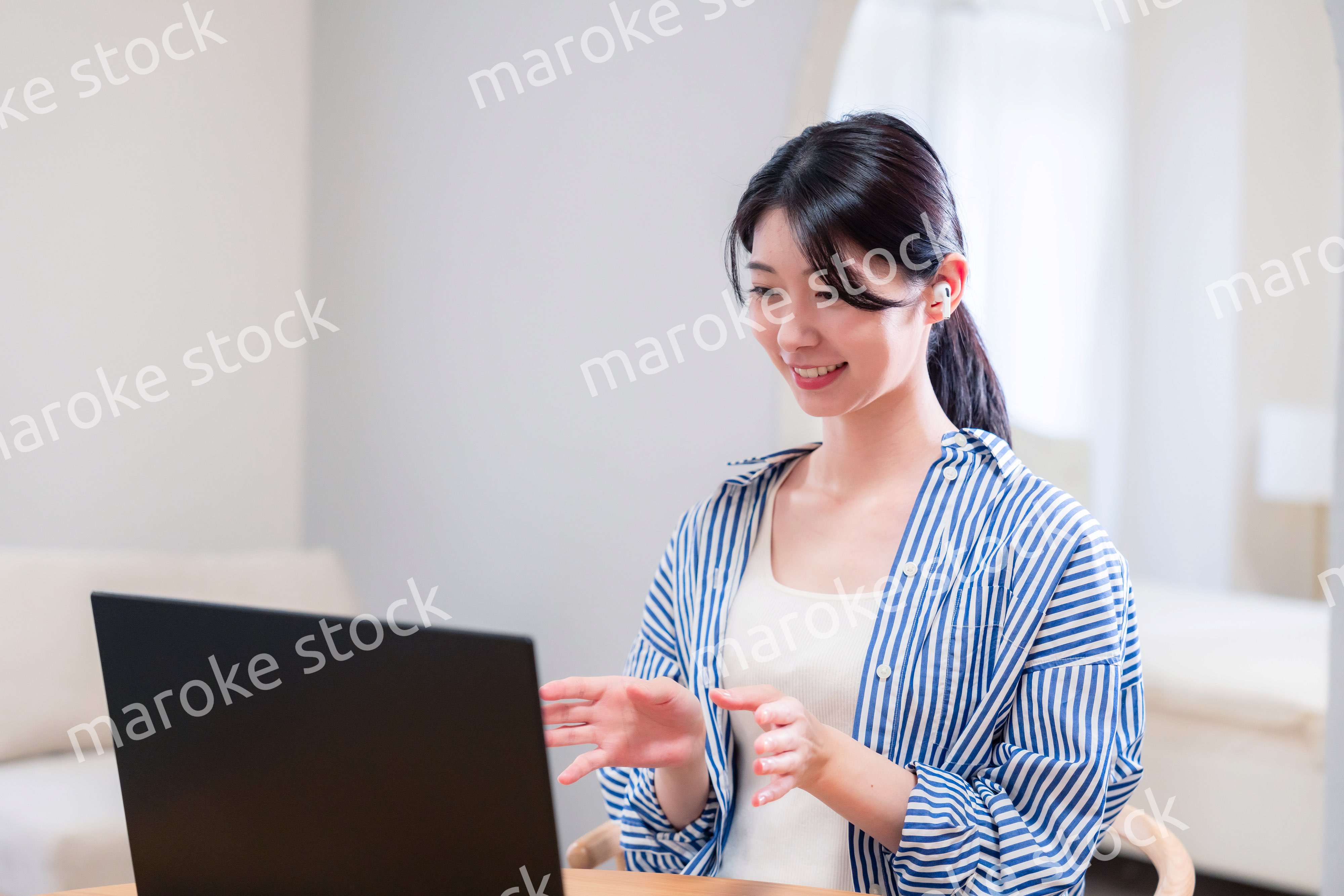 在宅でリモート会議に参加する若い女性社員