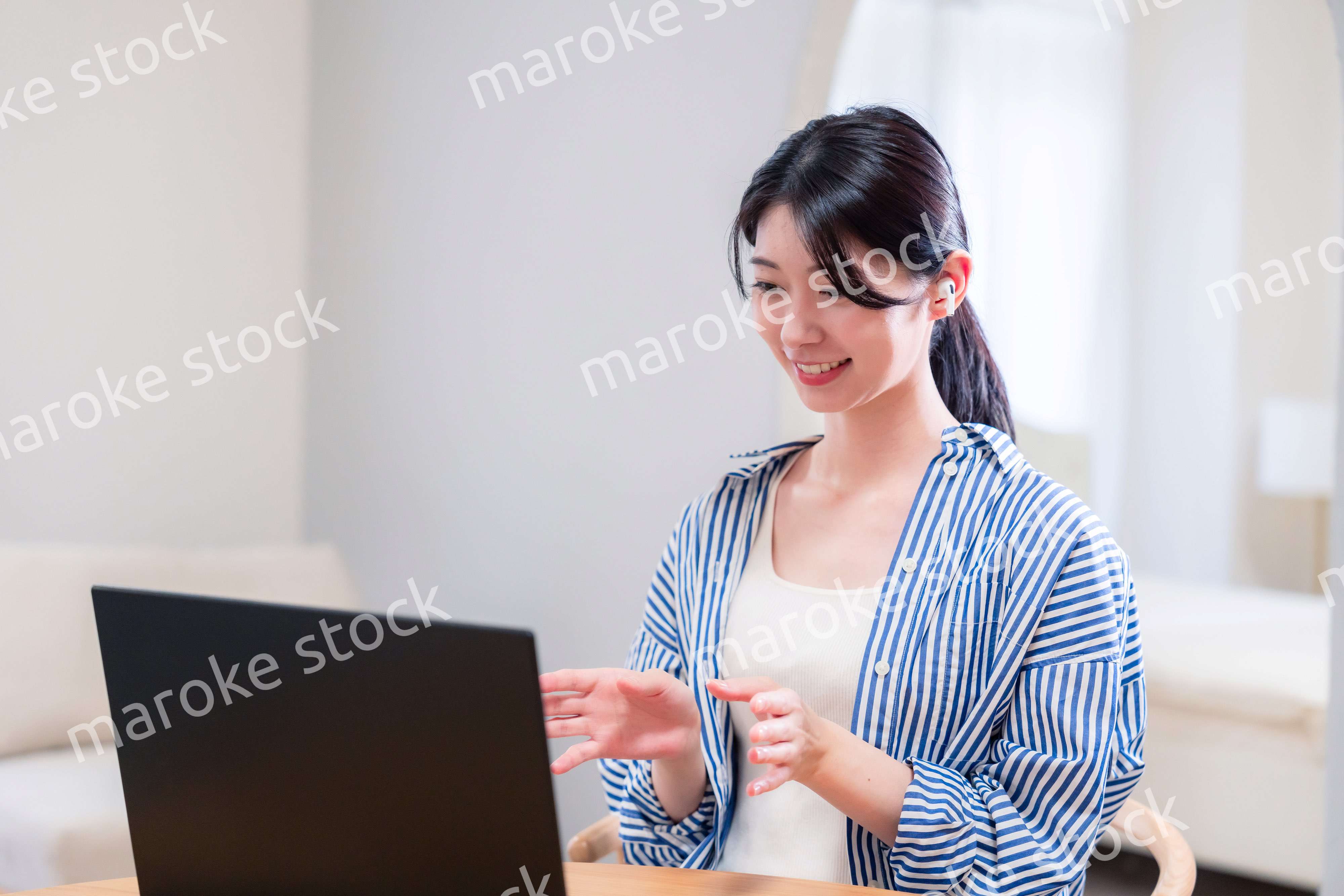 在宅でリモート会議に参加する若い女性社員