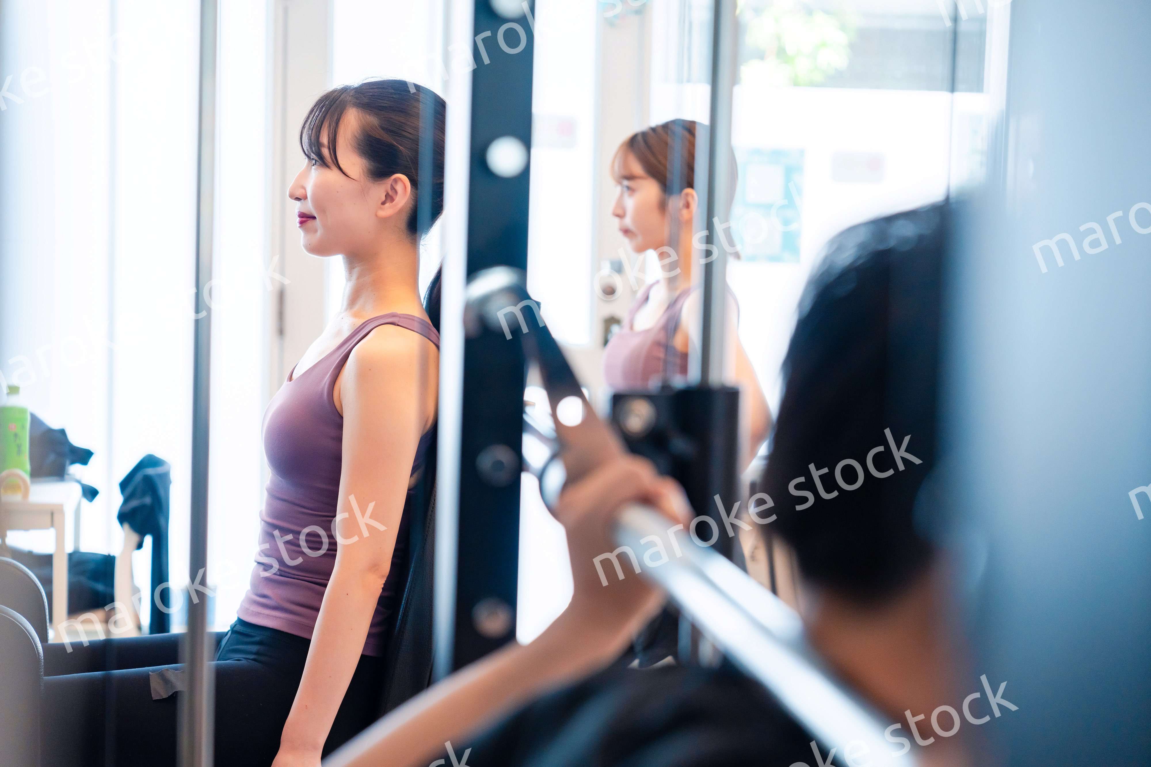 ジムのマシーンでトレーニングをする人