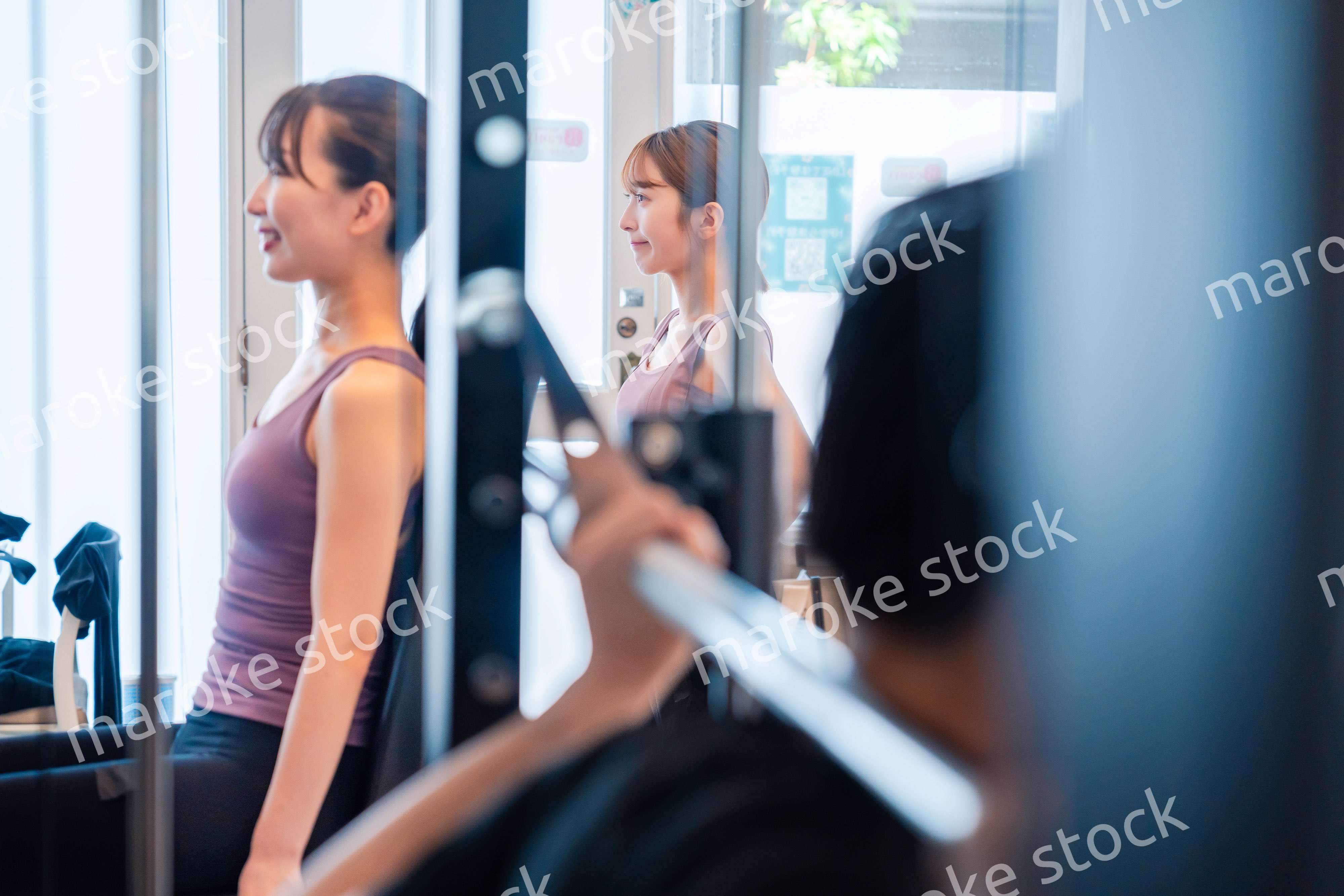 ジムのマシーンでトレーニングをする人