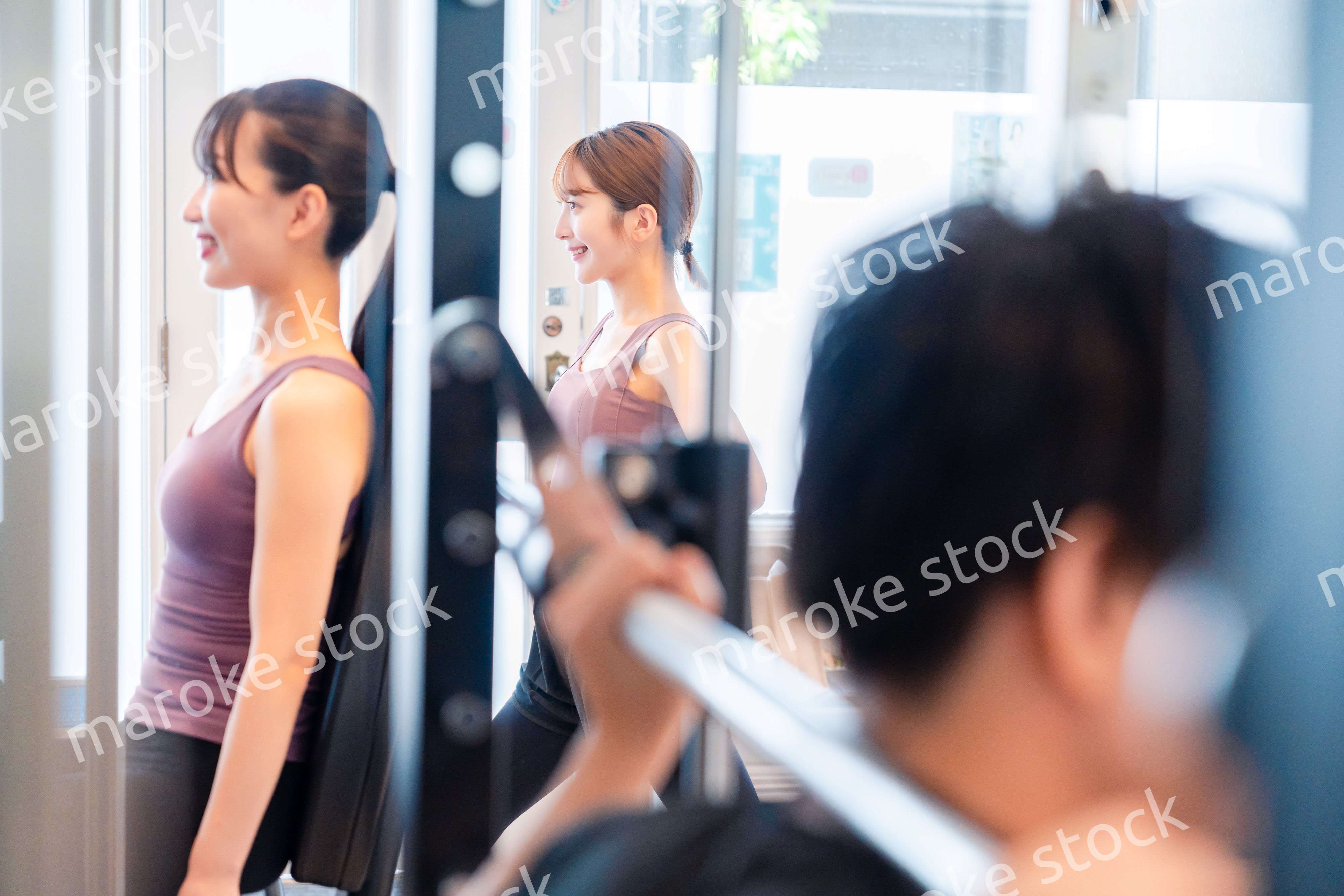 ジムのマシーンでトレーニングをする人