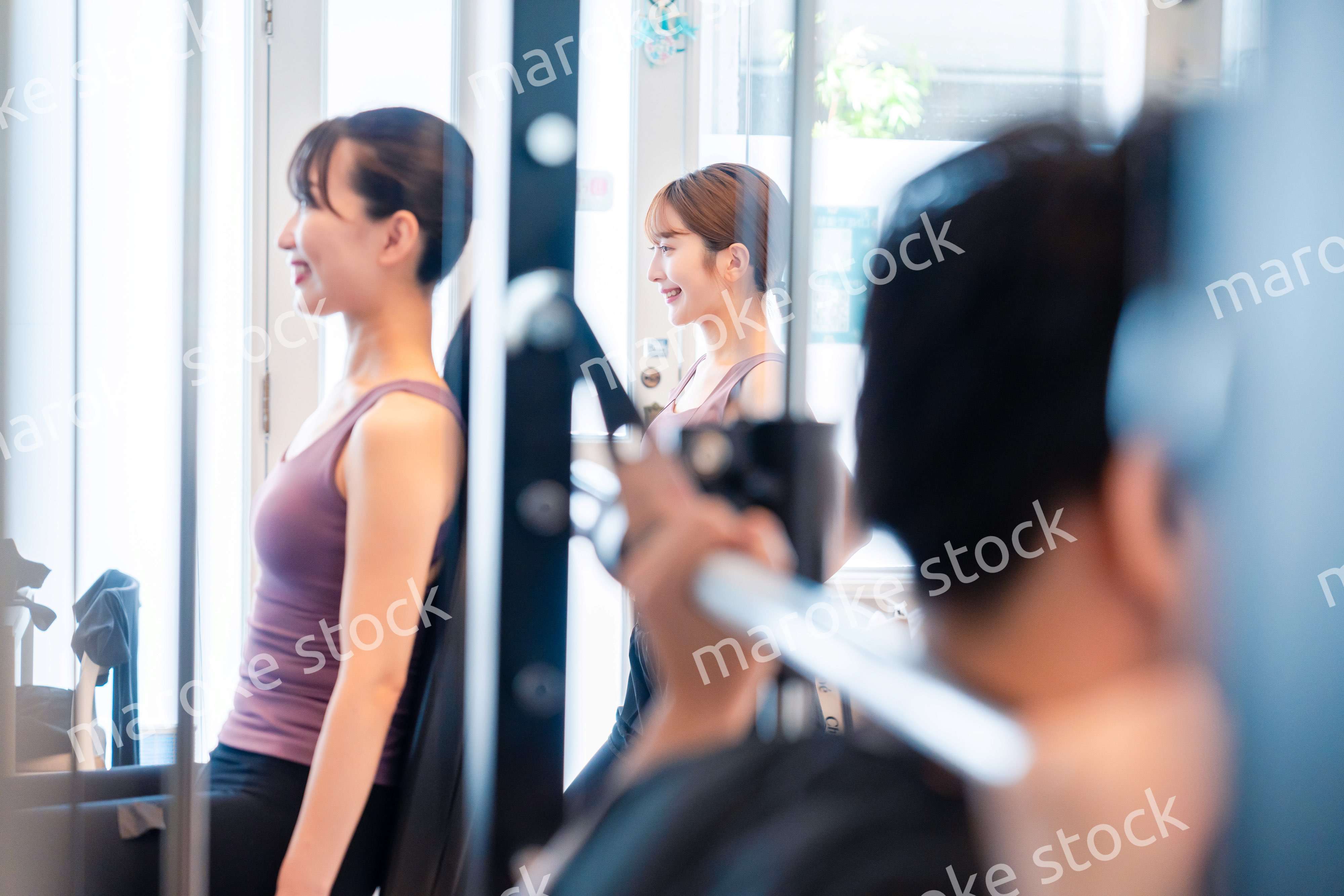 ジムのマシーンでトレーニングをする人