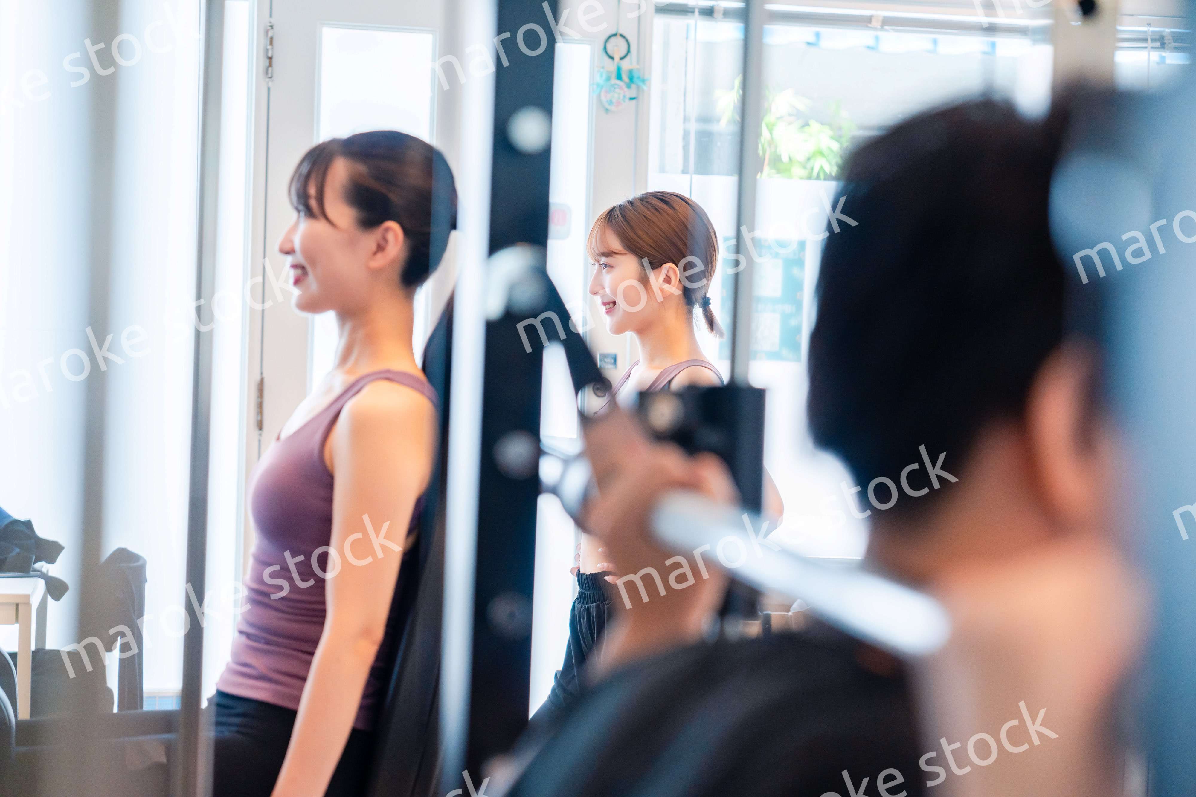 ジムのマシーンでトレーニングをする人