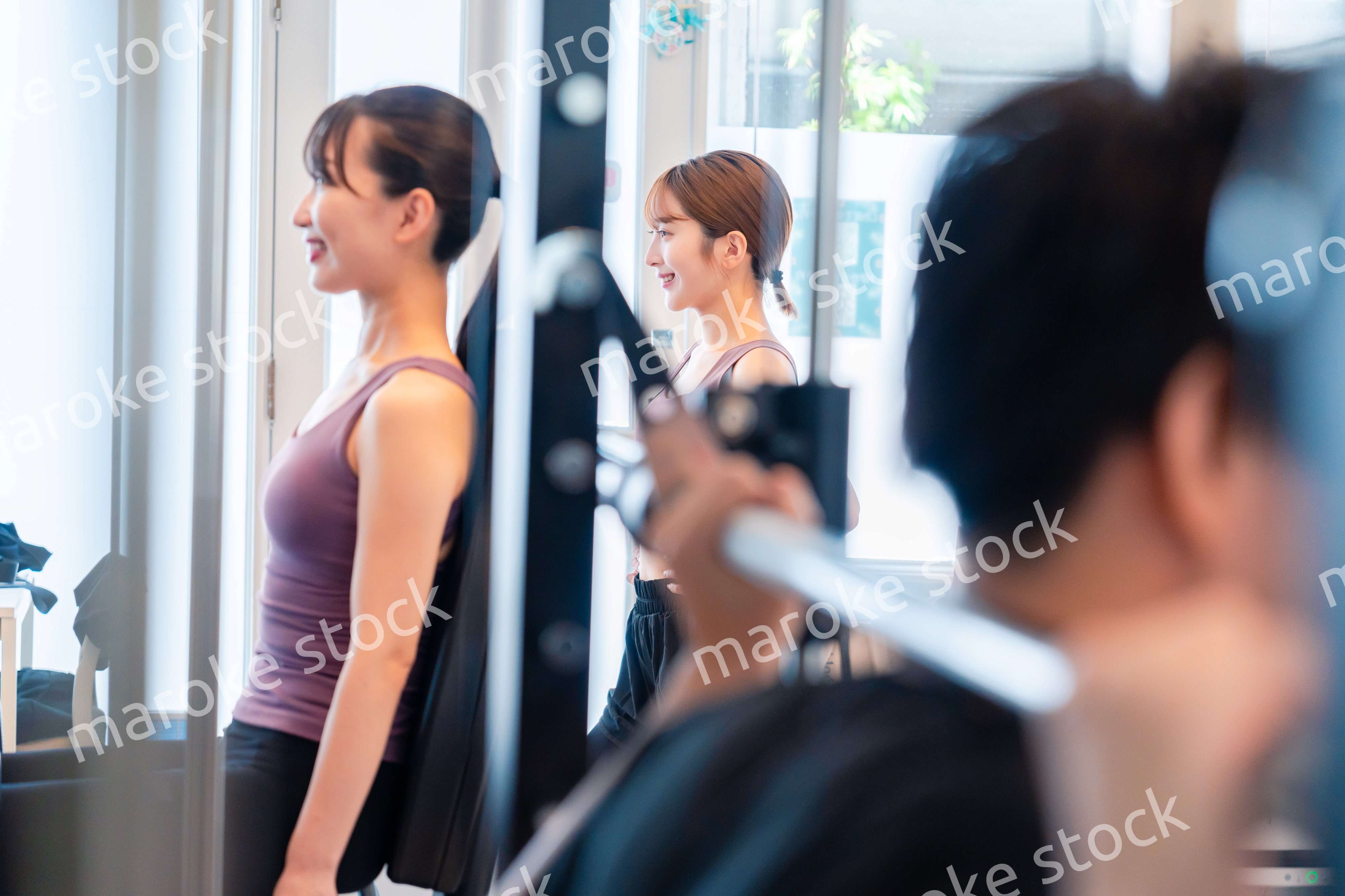 ジムのマシーンでトレーニングをする人