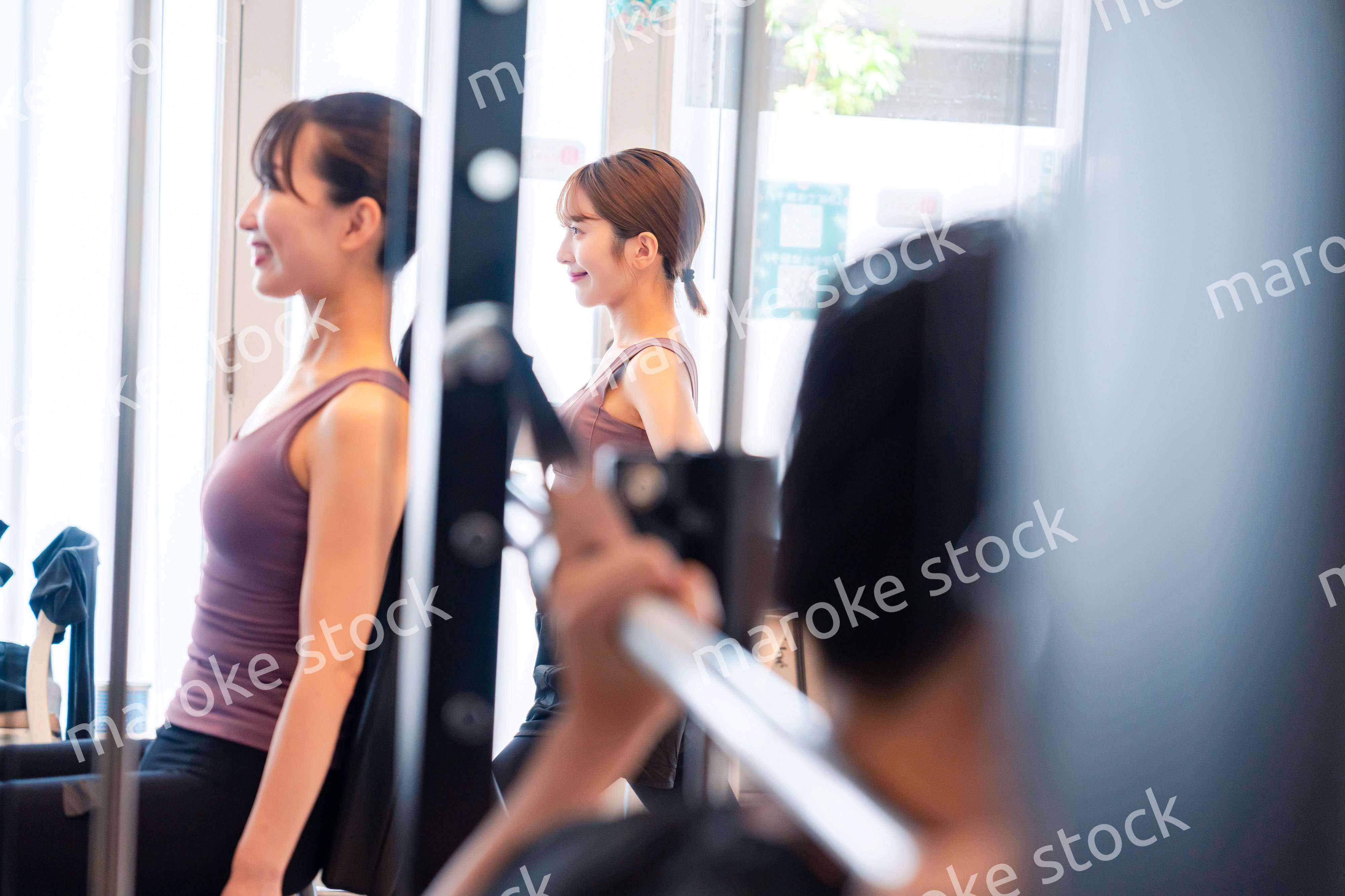 ジムのマシーンでトレーニングをする人