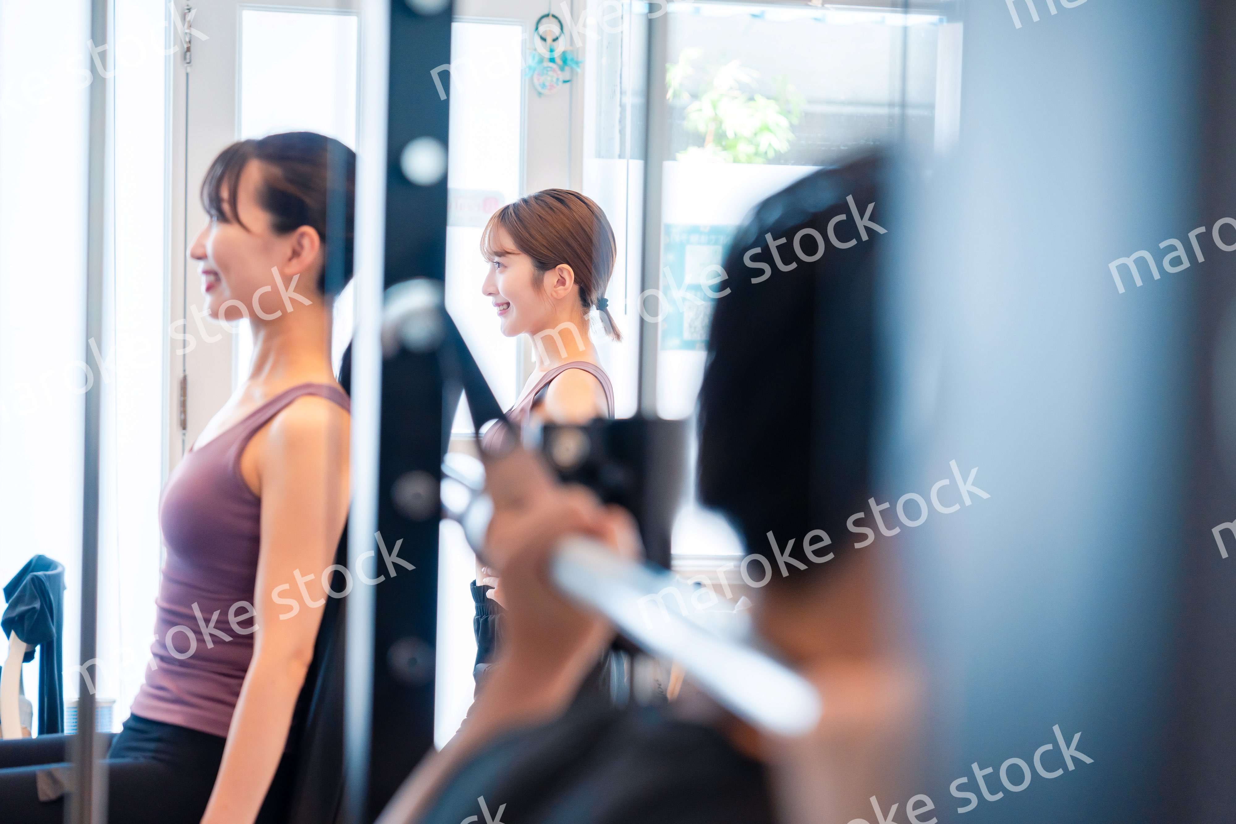 ジムのマシーンでトレーニングをする人