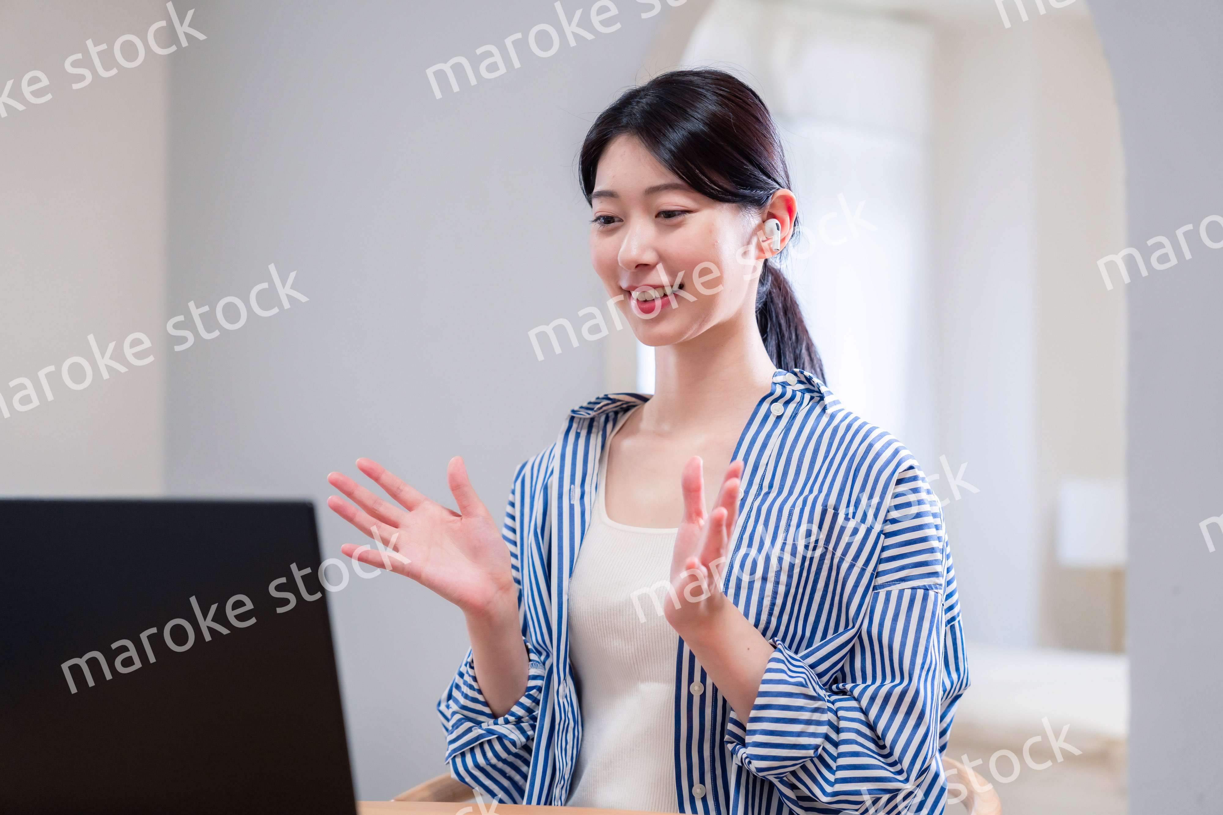 在宅でリモート会議に参加する若い女性社員