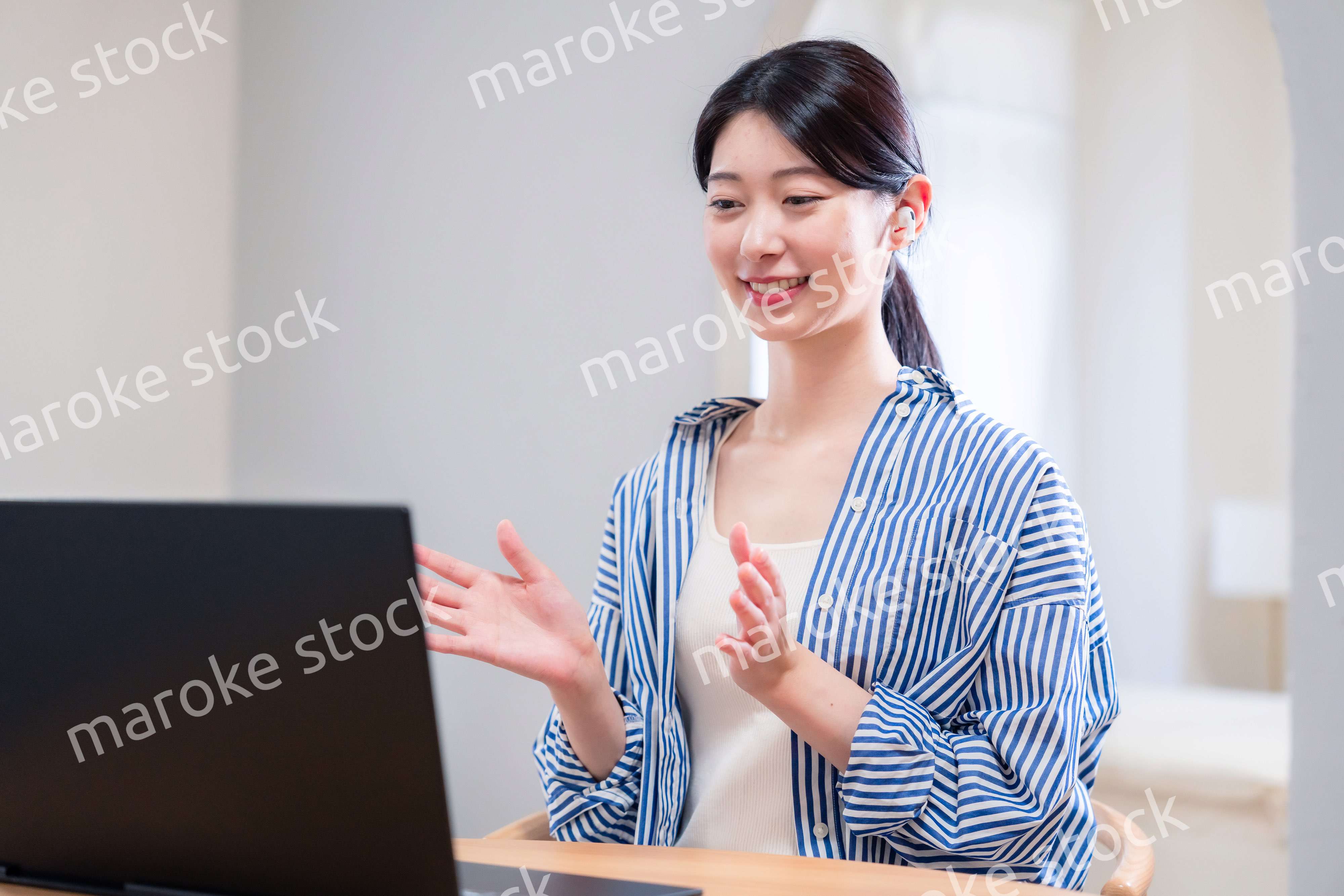 在宅でリモート会議に参加する若い女性社員