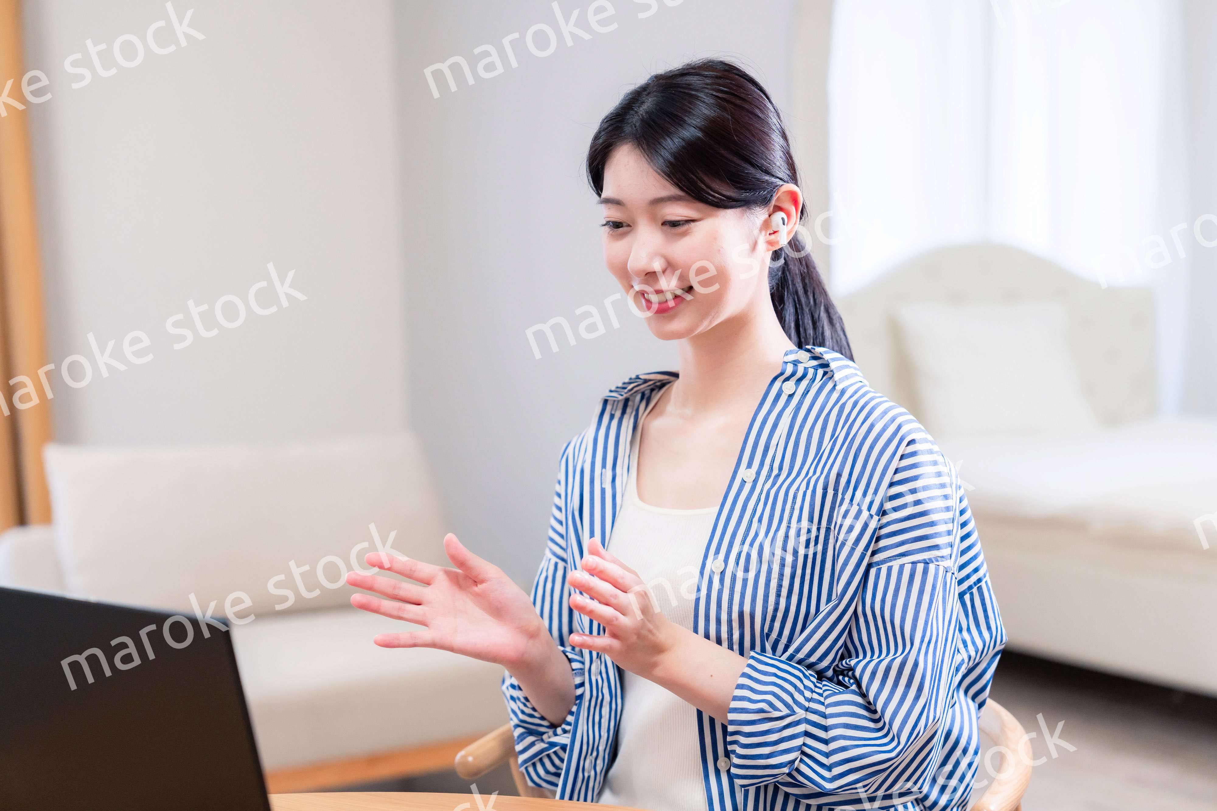 在宅でリモート会議に参加する若い女性社員