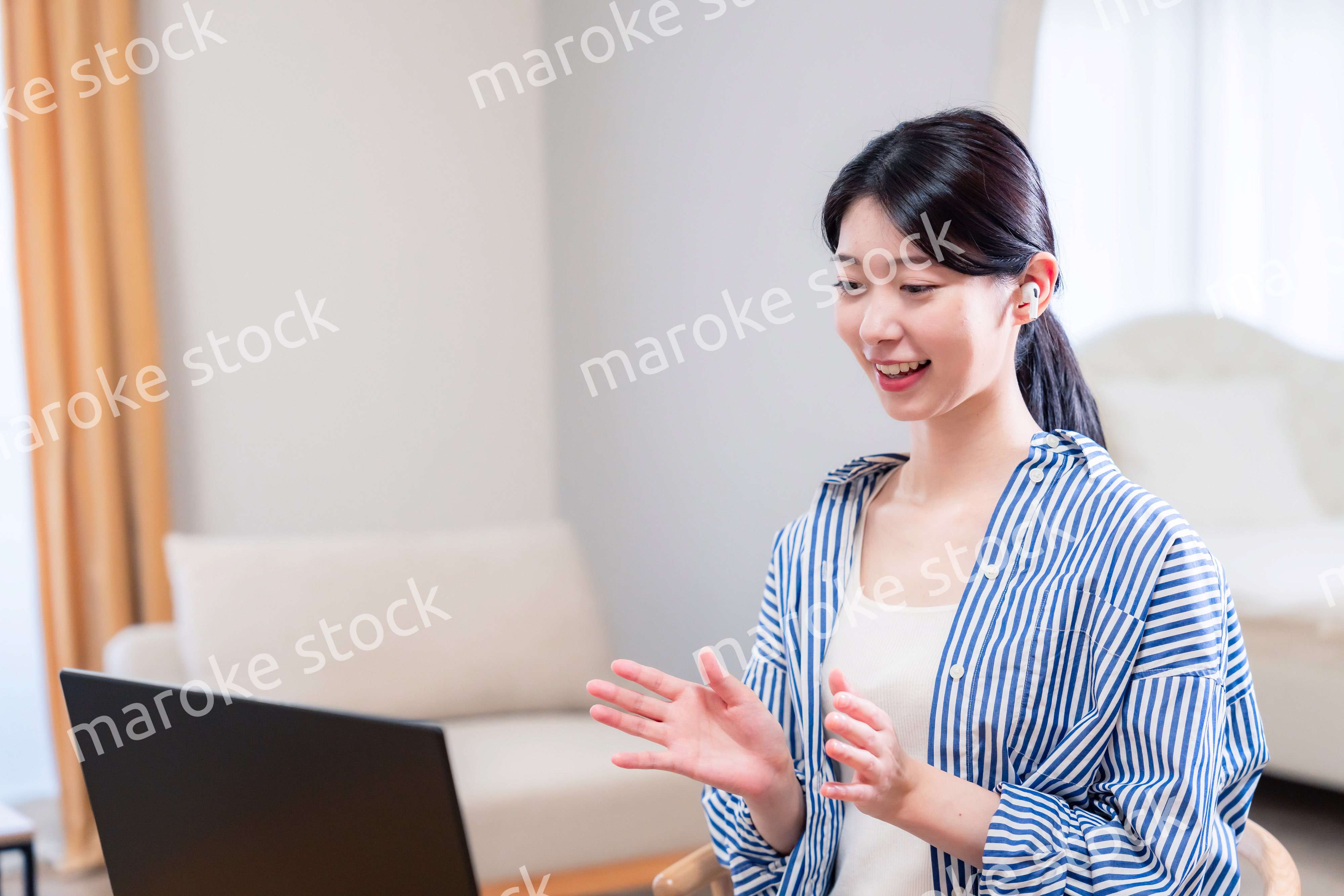 在宅でリモート会議に参加する若い女性社員