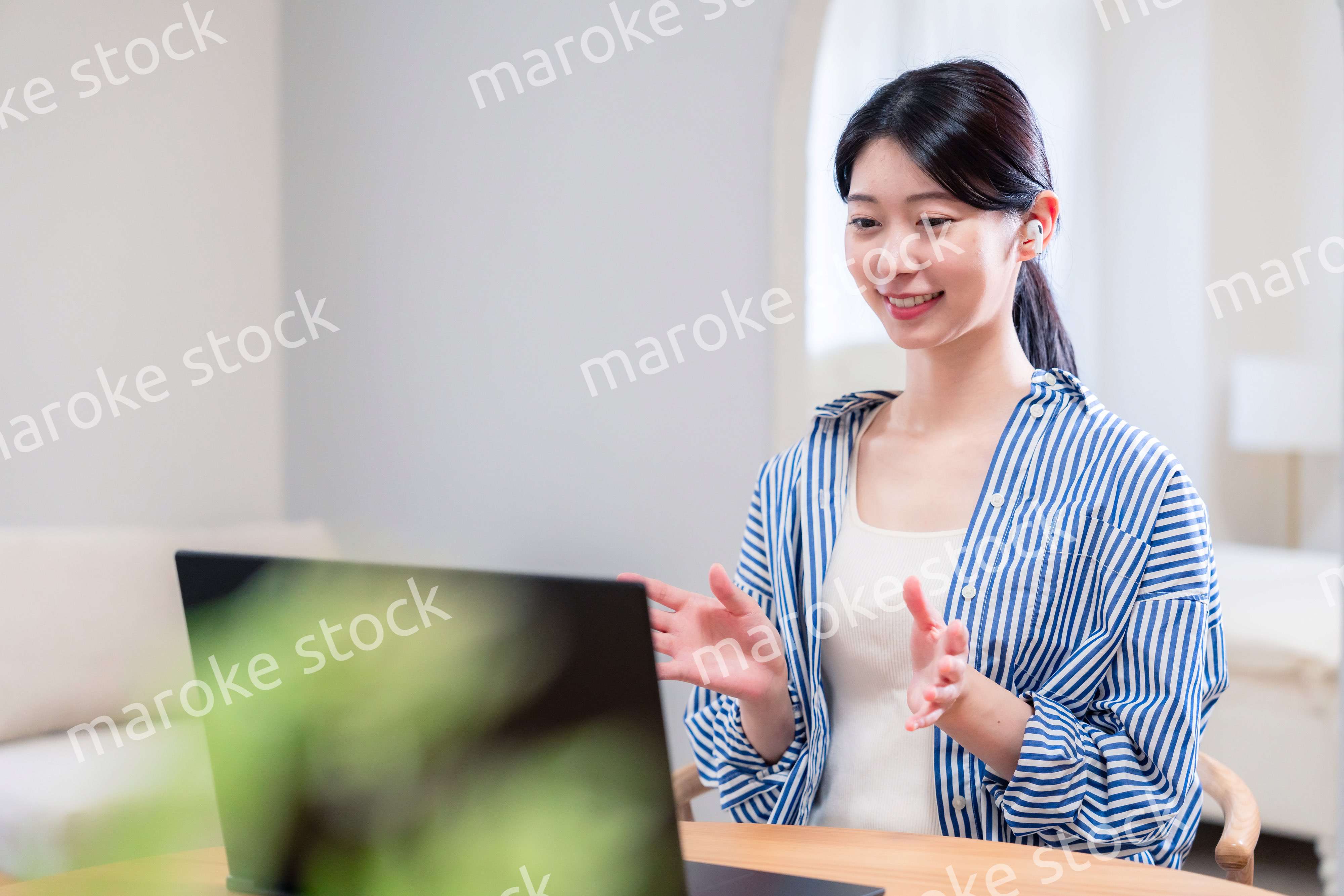 在宅でリモート会議に参加する若い女性社員