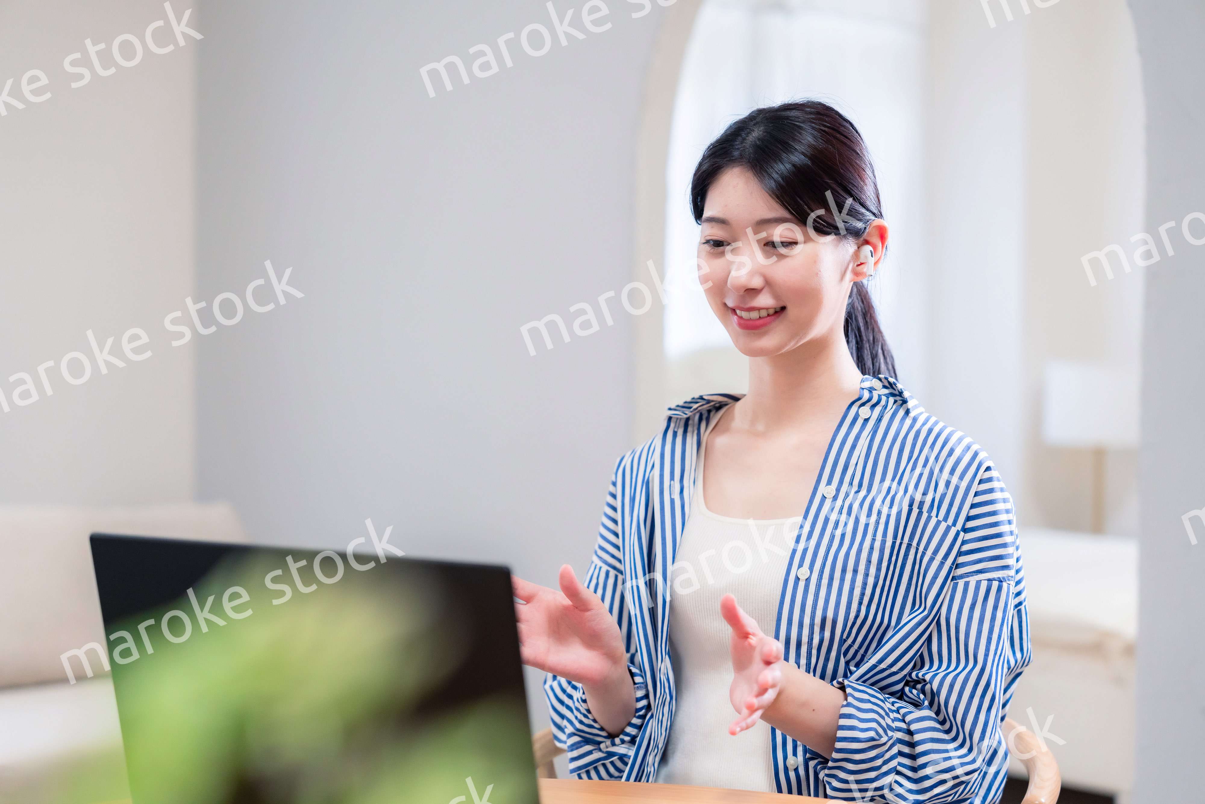 在宅でリモート会議に参加する若い女性社員